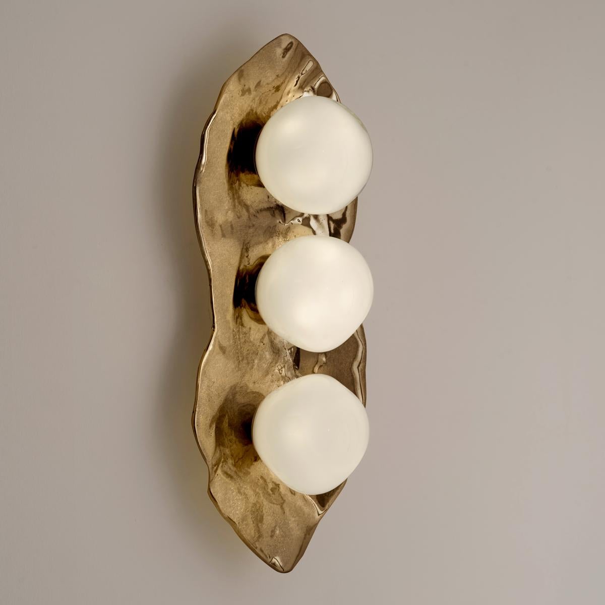 The Shell wall light is forged from brass to create an organic shell nestling three of our handblown Sfera glasses made in Murano.

Shown in the primary images in Bronzo Nuvolato-subsequent pictures show the fixture in other featured
