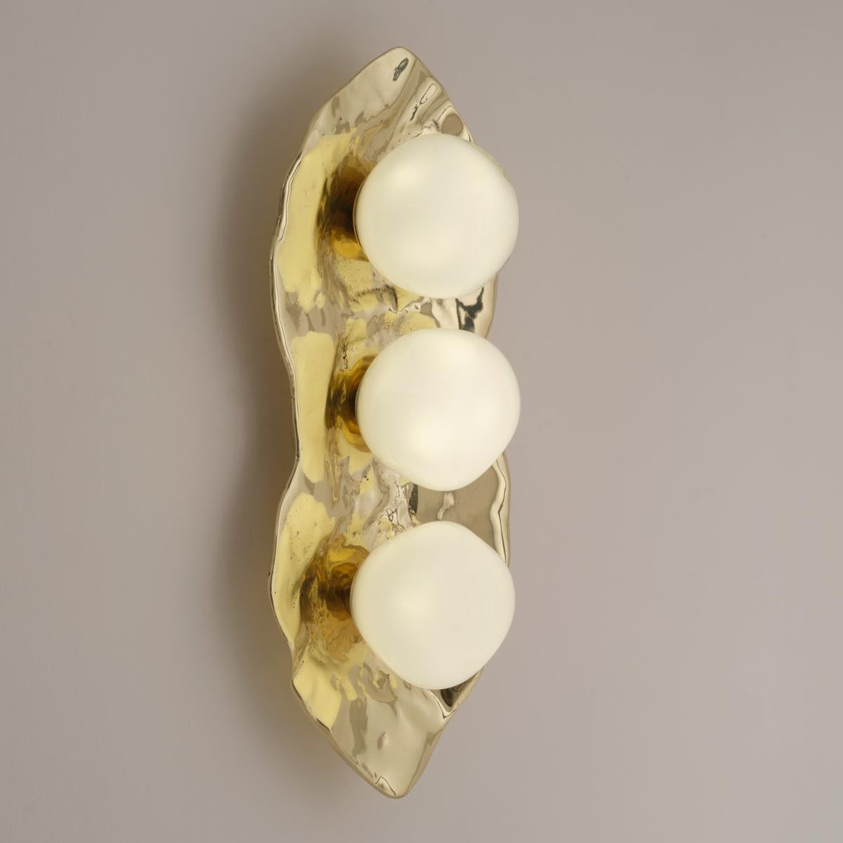 The Shell wall light is forged from brass to create an organic shell nestling three of our handblown Sfera glasses made in Murano.

Shown in the primary images in polished brass -subsequent pictures show the fixture in other featured