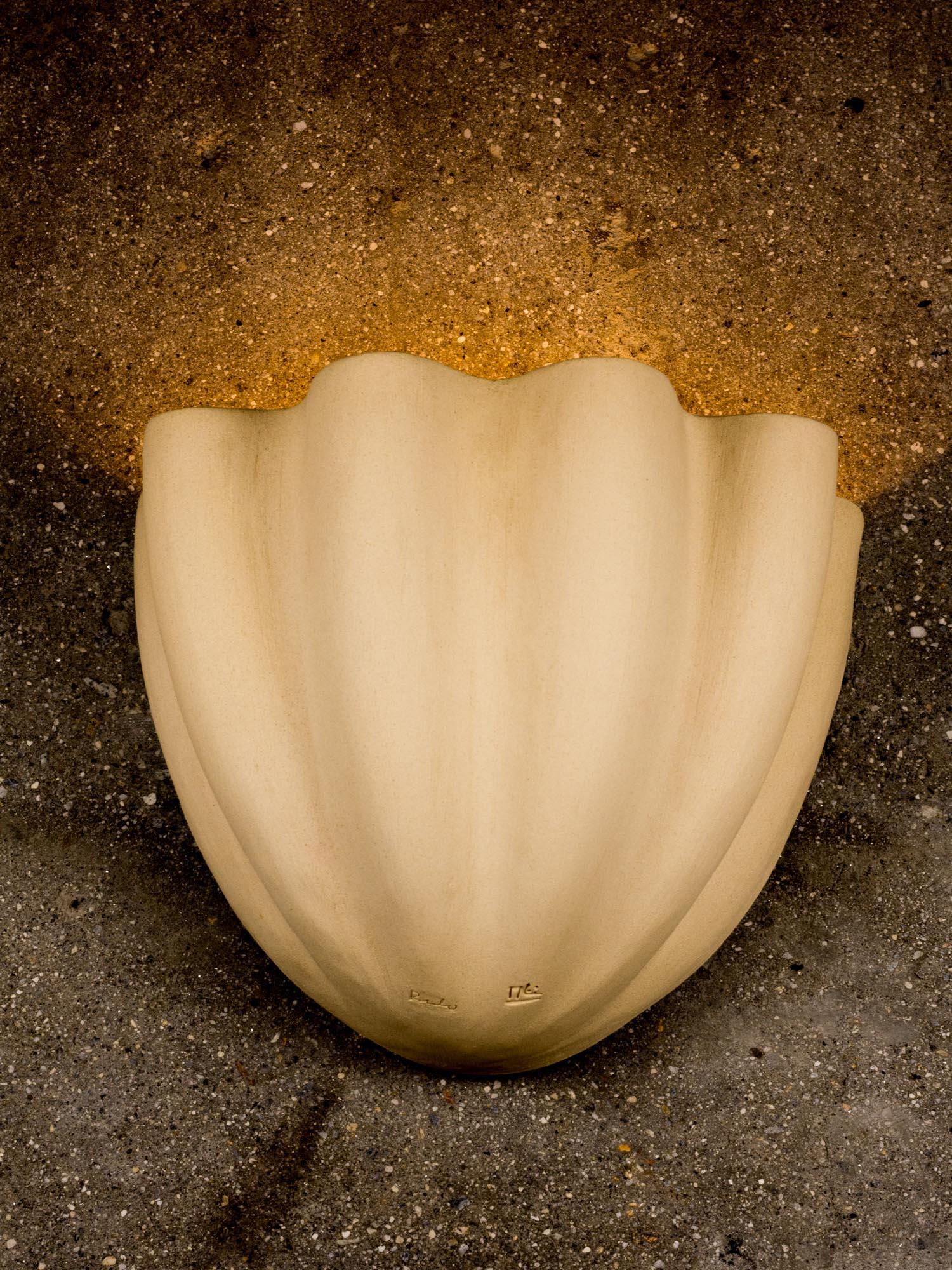 Grande applique in ceramica a forma di conchiglia, disegnata e firmata da Rulo e Manolo Eirin. Interno ed esterno vetrificato in bianco sporco, che consente una maggiore proiezione di luce sulla parete. La lampada da parete è progettata sia per