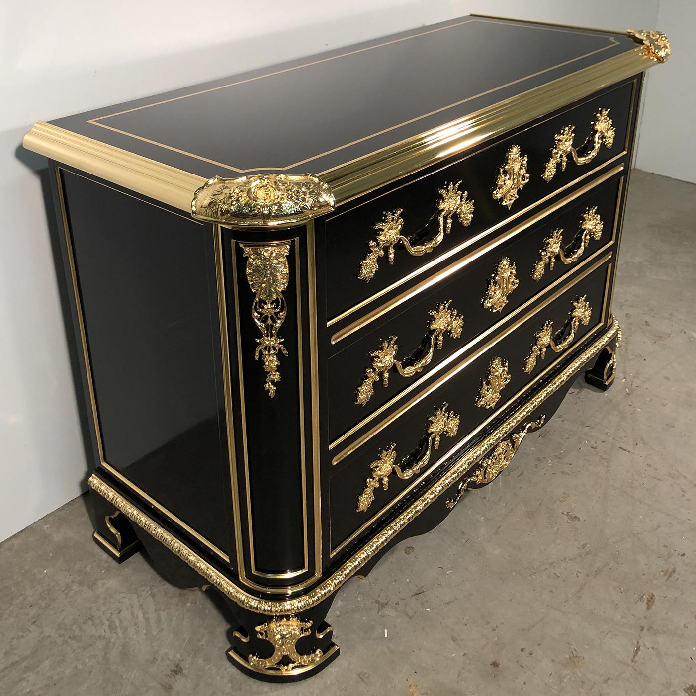 This exquisite chest of drawers creates an opulent feel in any living space. Crafted from solid wood with a hand-applied black lacquered shellac finish, the design is enhanced with meticulously detailed 22-karat gold leaf accents and 22-karat