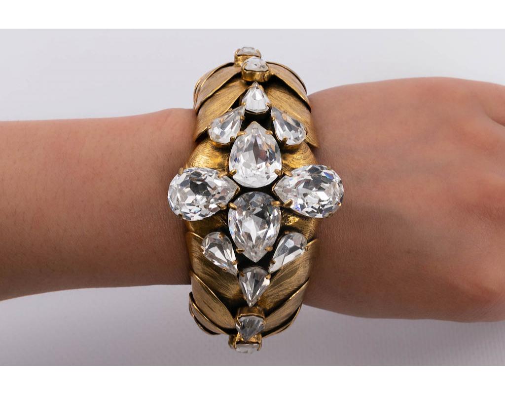 Golden metal bracelet composed of elements representing shells, decorated with rhinestones.

Additional information:
Condition: Very good condition
Dimensions: Circumference: 15 cm (5.9