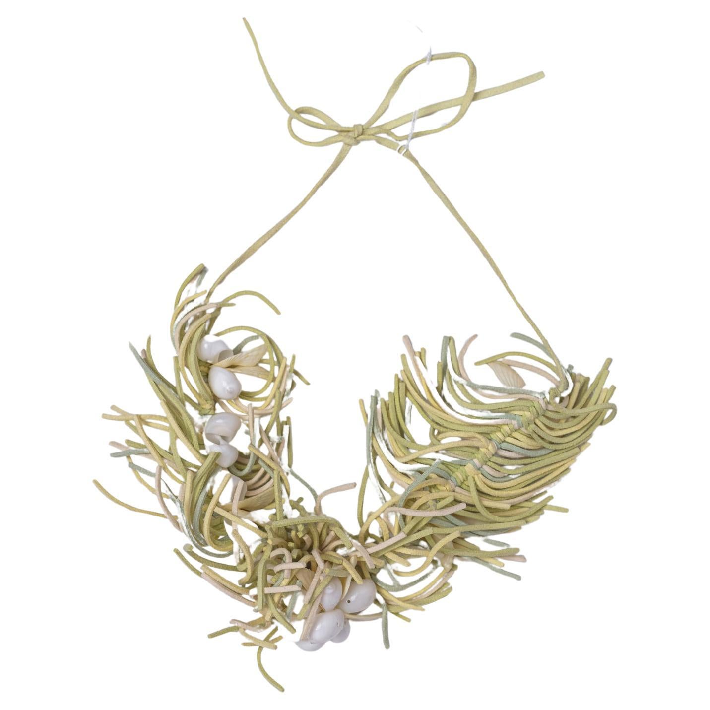 The necklace was placed on a small base of cm. 20x h.28, so it seems very big , but IT IS instead of a NORMAL SIZE.
Central part with light green lighr yellow leather fringes and little shells.
Sizes of necklace: cm. 26 + 31 cm. rope of each side
It