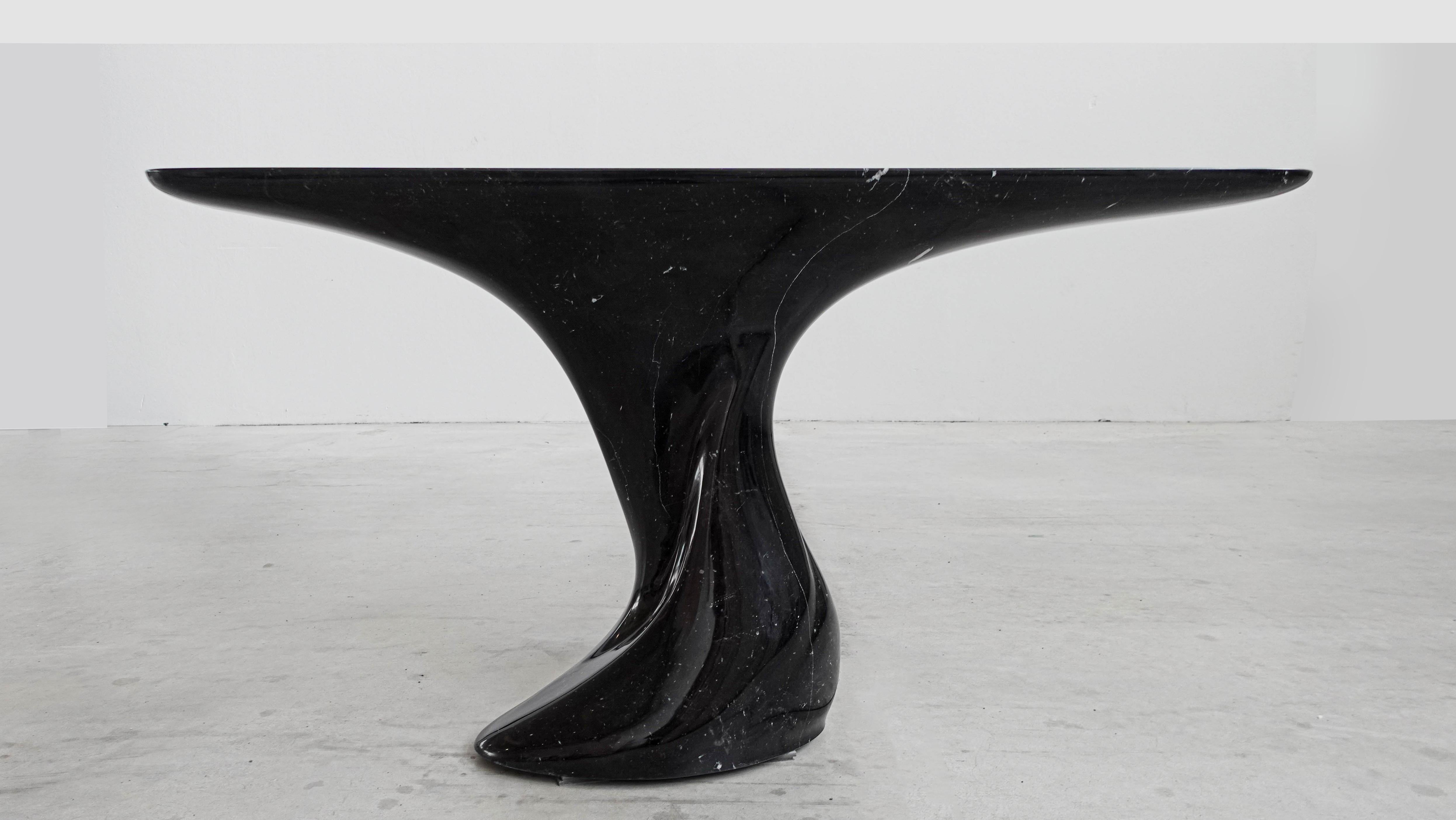 The Shelly Console Table is a sculptural masterpiece that redefines the boundaries of furniture design. Crafted from exquisite Nero Marquina marble, it embodies the perfect balance between strength and fluidity. Its organic silhouette, designed by