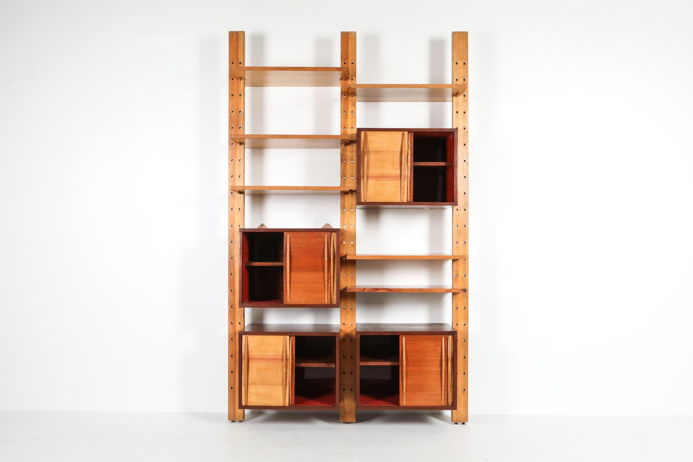 Mid-Century Modern 'bibliotheque', 1970s architect edition, in the style of Charlotte Perriand, Le Corbusier.

The wall unit exists out of 3 poles, 4 cabinets and 6 shelves.
two-tone piece in beech and teak.

The system can be expanded with a