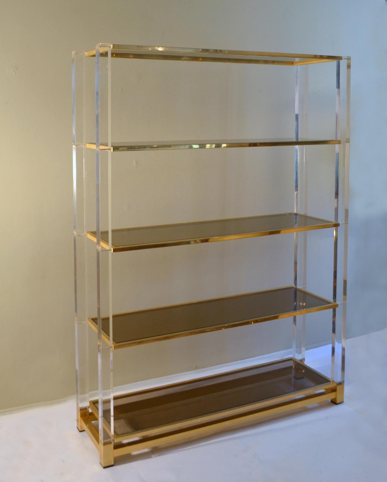 Illuminated Lucite and brass étagère/shelving unit with five smoke glass shelves with brass borders is designed by Charles Hollis Jones, known as the “Incredible Mister Lucite” with his studio based in L.A. This shelving unit is part of the 