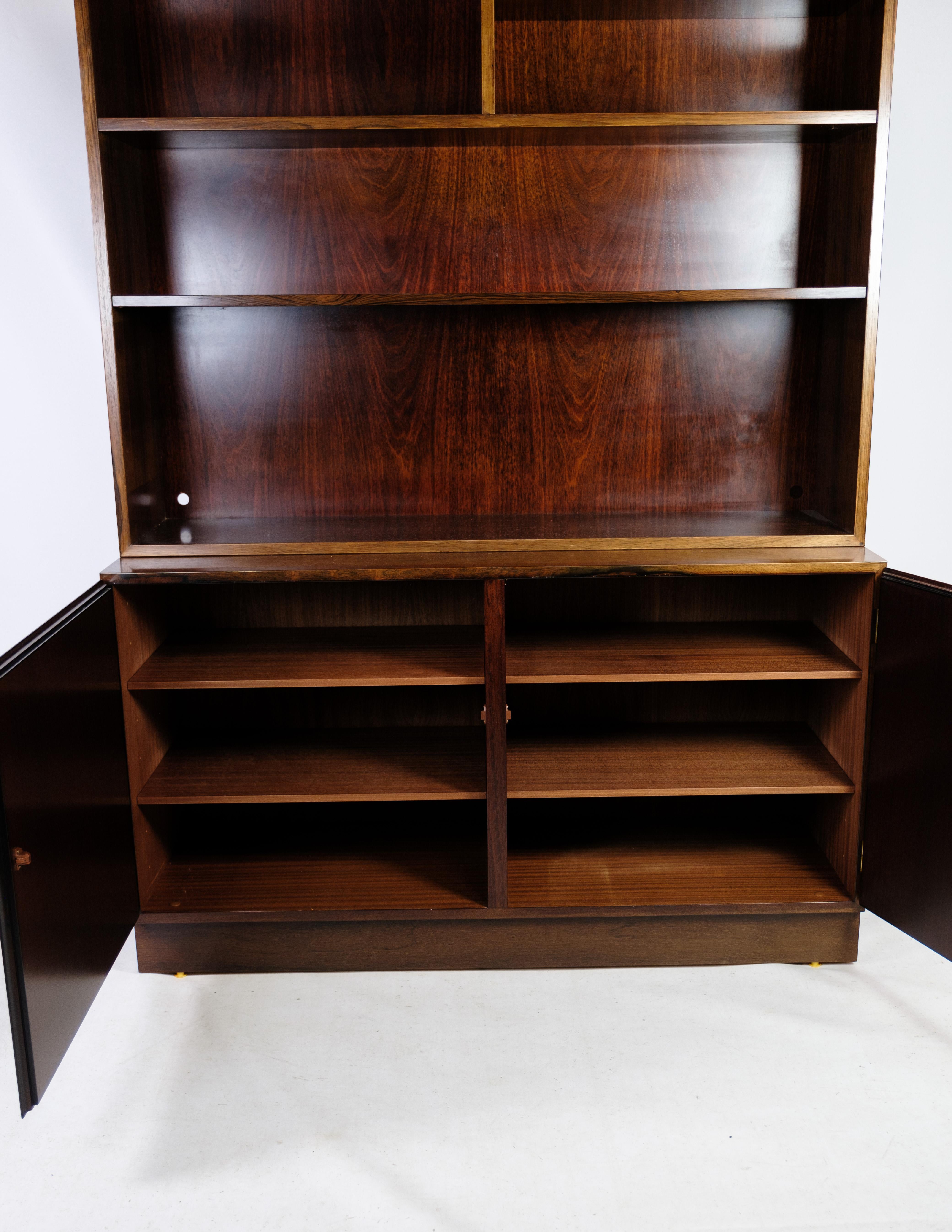 The Model 9 shelving system with secretary, crafted from luxurious rosewood, is a prime example of Danish design from the 1960s. Manufactured by Omann Junior's Møbelfabrik, this piece combines functionality with timeless elegance, showcasing the