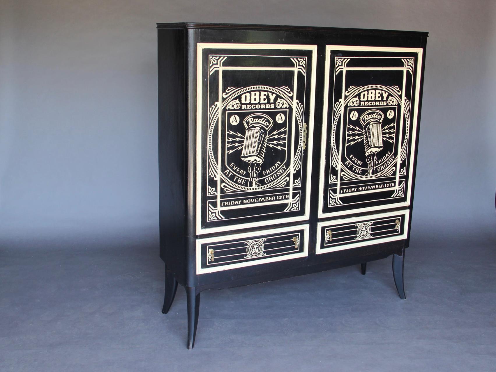 Iconic graphic Graffiti Artist Shepard Fairey designed this cabinet to benefit an Arts and Music School in San Francisco, circa 2005.
The stenciled design is typical of Fairey. The word OBEY is found in the majority of his work as well as the face