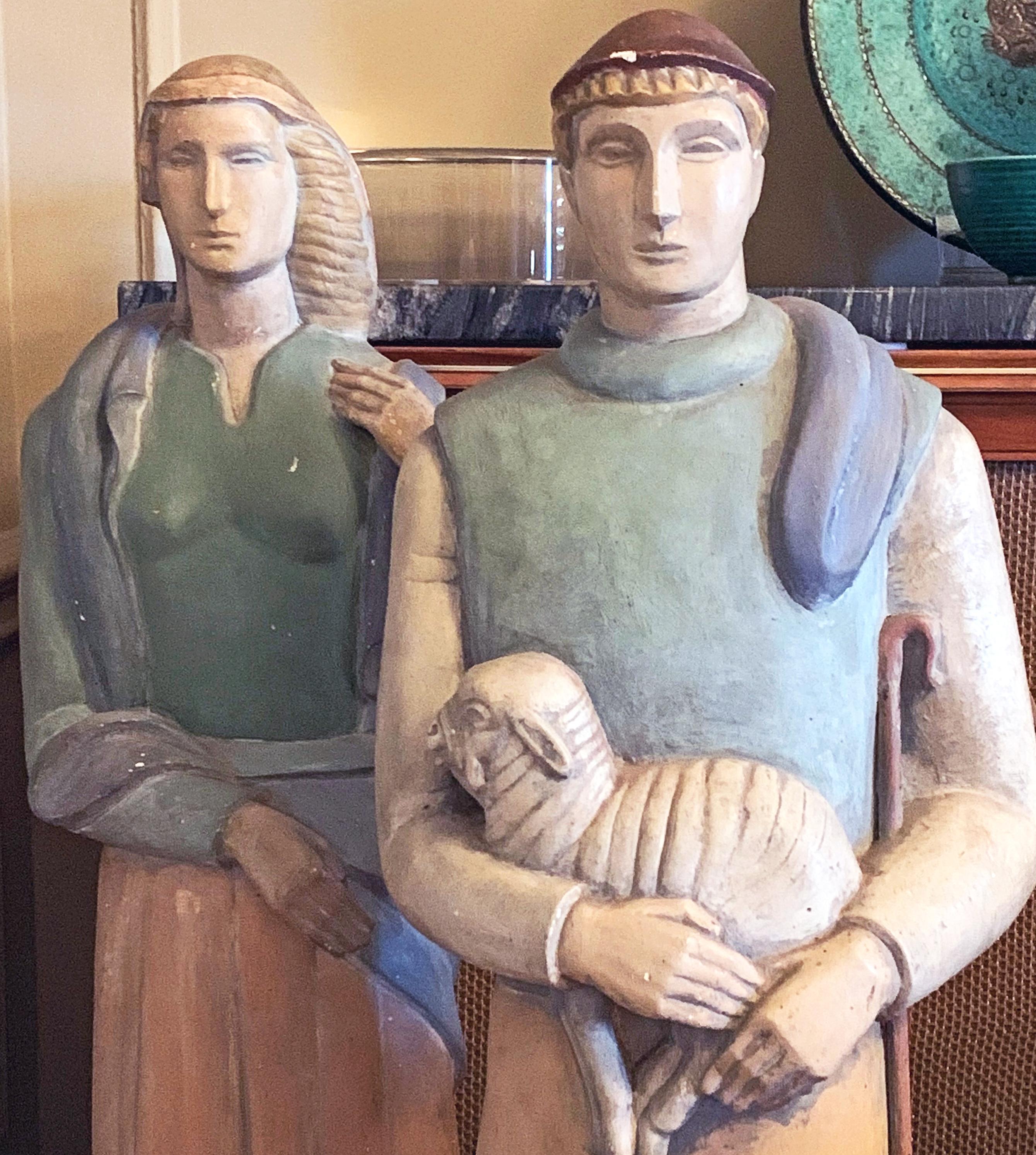 Monumental and dignified, this pair of Art Deco sculptures depict a shepherd and shepherdess, crisply shaped and stylized like the best of 1930s public sculpture, and painted in rich but subdued colors with an effect like sun-bleached stucco. It is