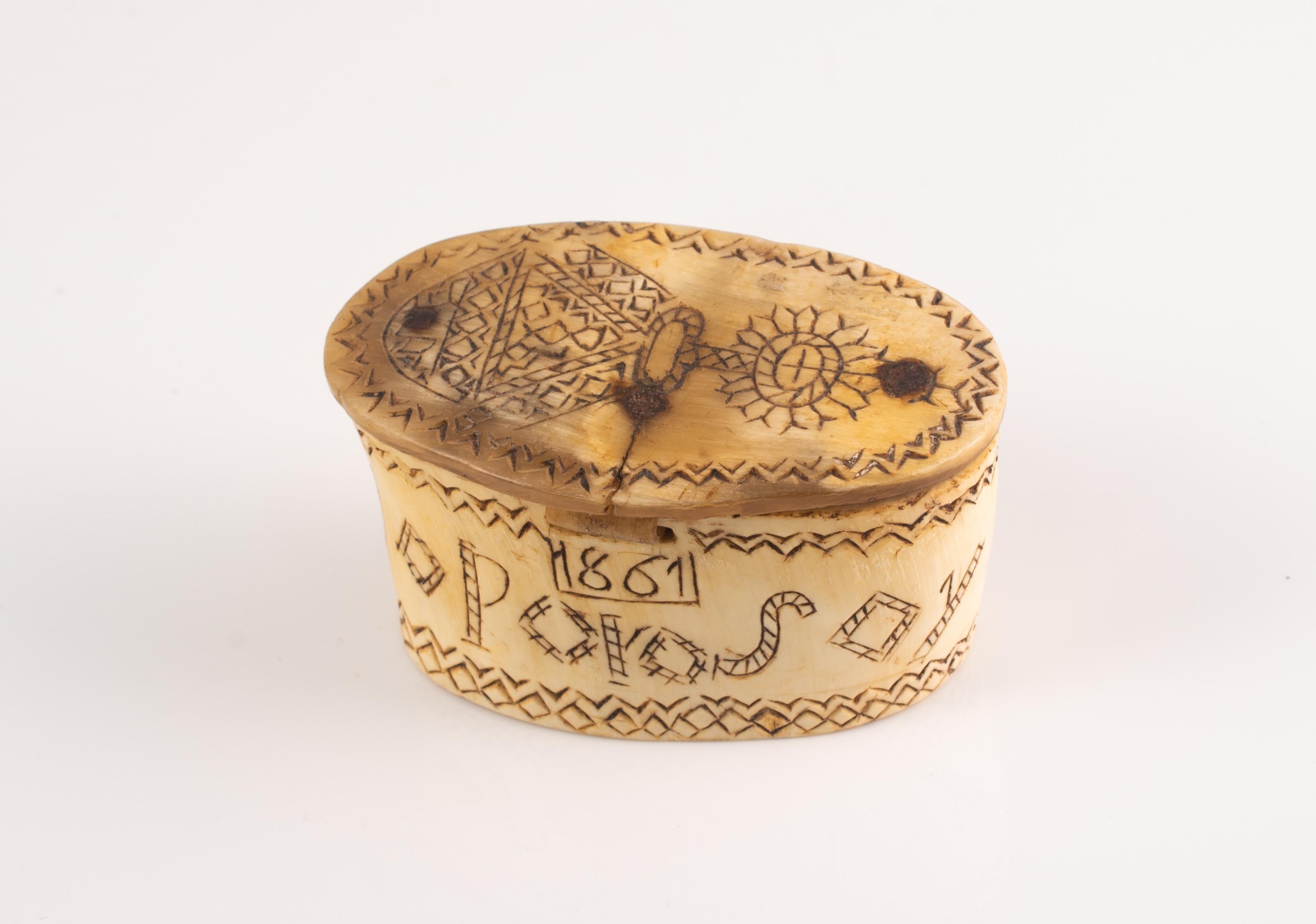 Caja pastoral. Asta tallada, madera, metal. Spanish School, 1861. 
Presenta las inscripciones. 
Caja ovalada de asta tallada en su color, con madera en la tapa para reforzarla, decorada en el exterior con una serie de elementos grabados. En la base