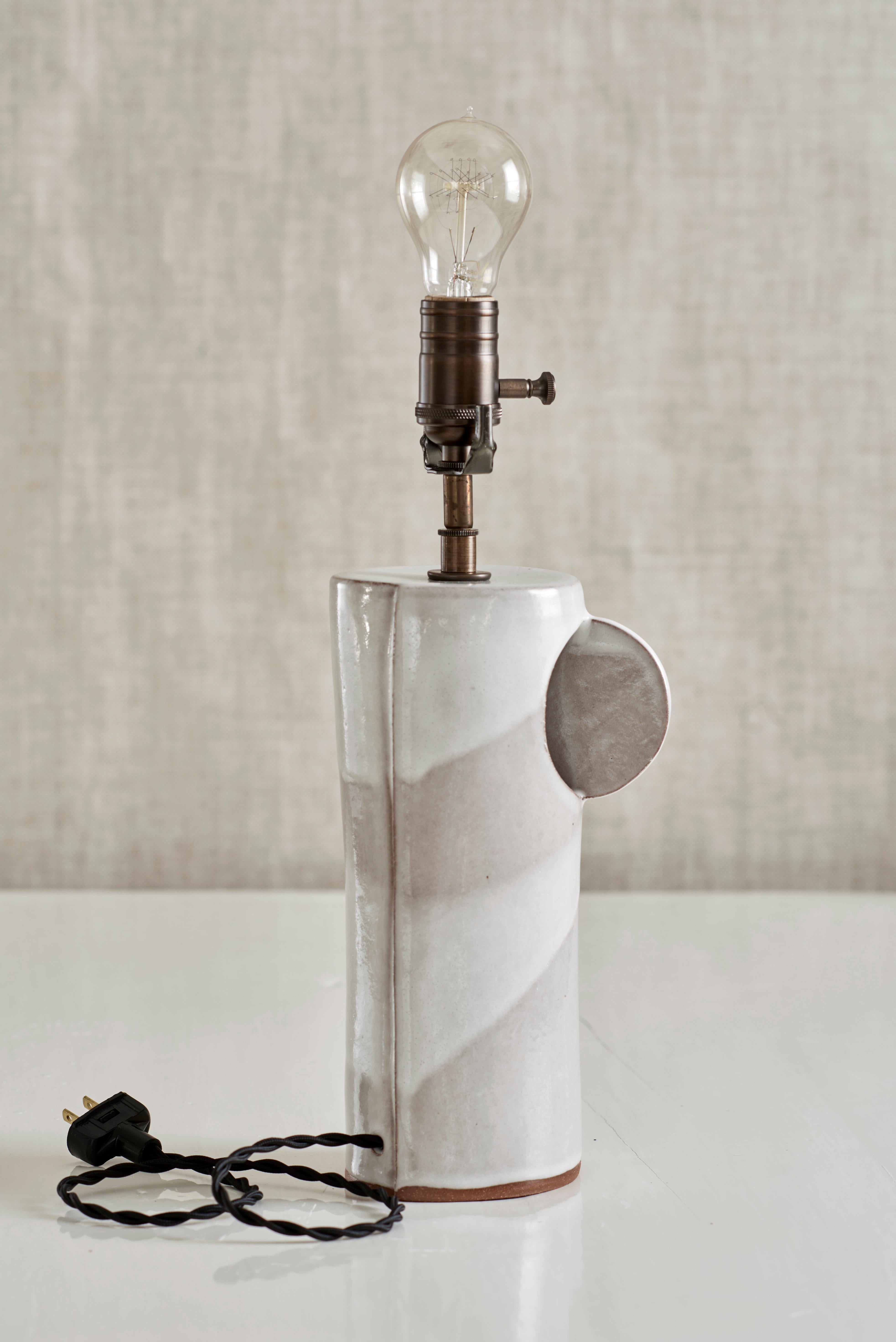 Handmade stoneware slab construction. Lamps are individually crafted and one of a kind.

White glaze. Antique brass fittings with braided black silk cord and black linen shade.

Column height 10.5”
Column width 4.25