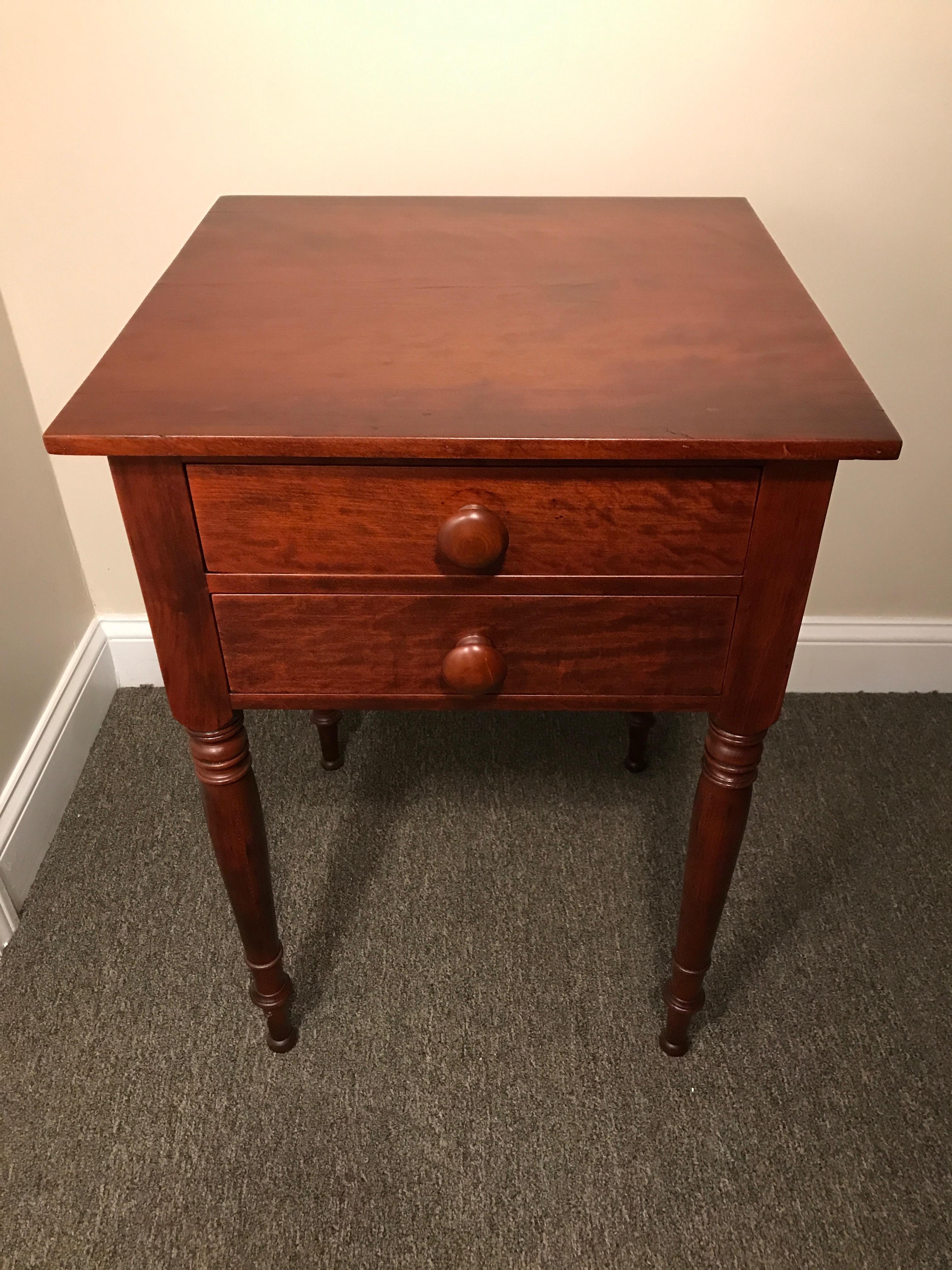 Sheraton 2-drawer stand in cherry, circa 1820 North shore, Massachusetts. Figured cherry drawers, turned legs, dovetailed drawers and wooden knobs. Recently refinished in our shop. A fine example of a Sheraton 2-drawer in cherry. Measures: 20