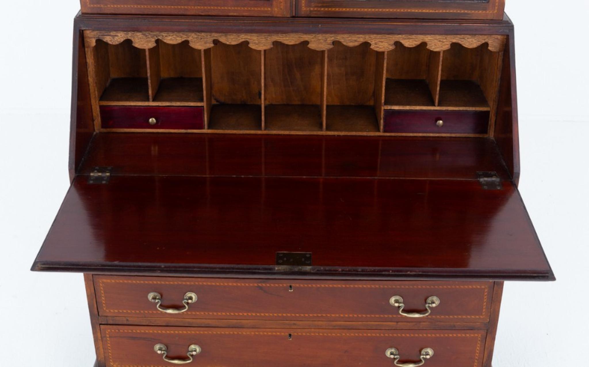 Libreria bureau in mogano Sheraton Revival
Questa libreria bureau è sollevata da piedini a staffa sagomati.
La parte inferiore è composta da 4 cassetti graduati rivestiti in Oak con maniglie a collo di cigno in ottone.
La caduta si apre per rivelare