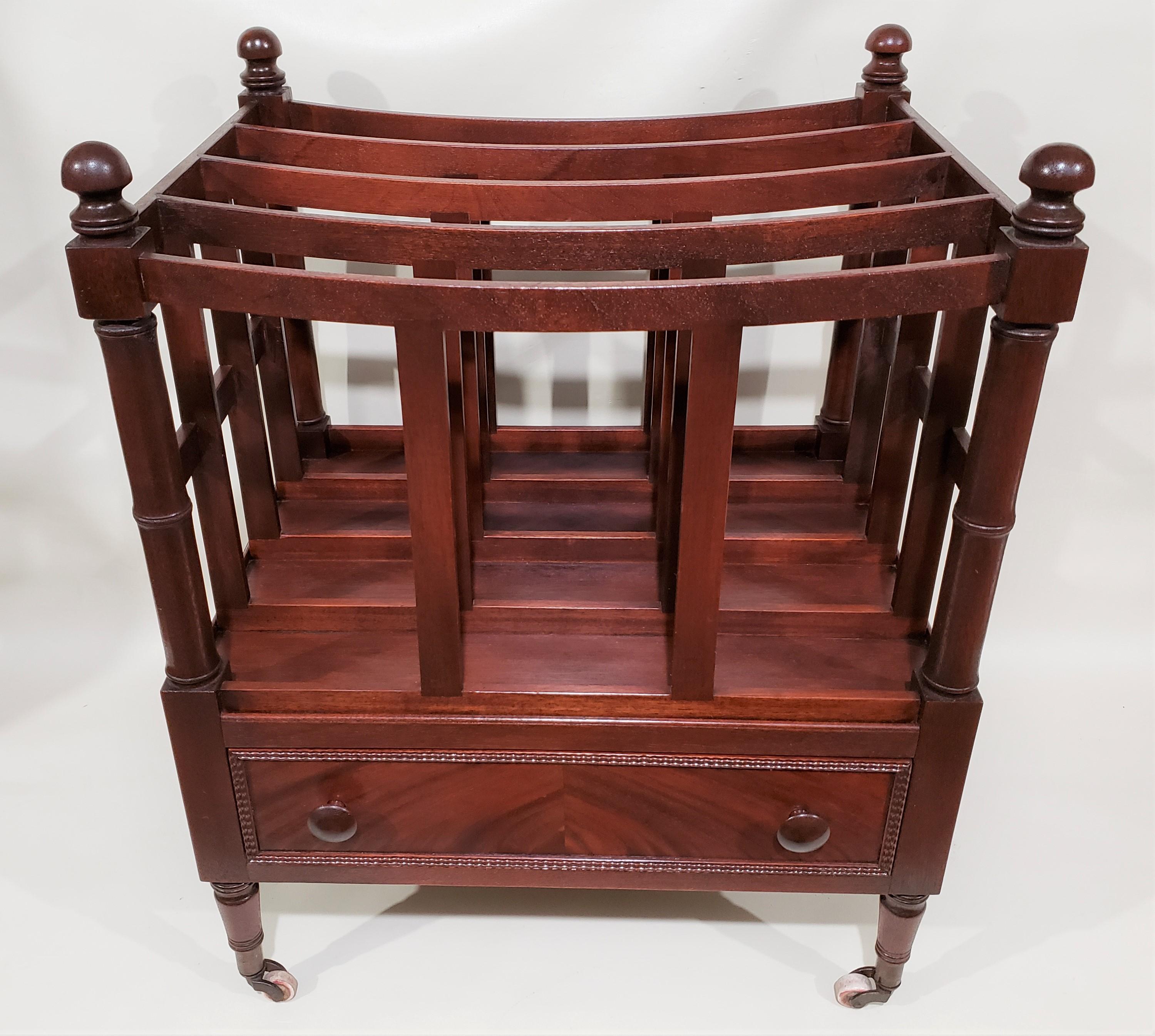 Late Sheraton English Canterbury in mahogany with four ring turned corner supports ending in brass castors. It features four downswept dividers above a single drawer.