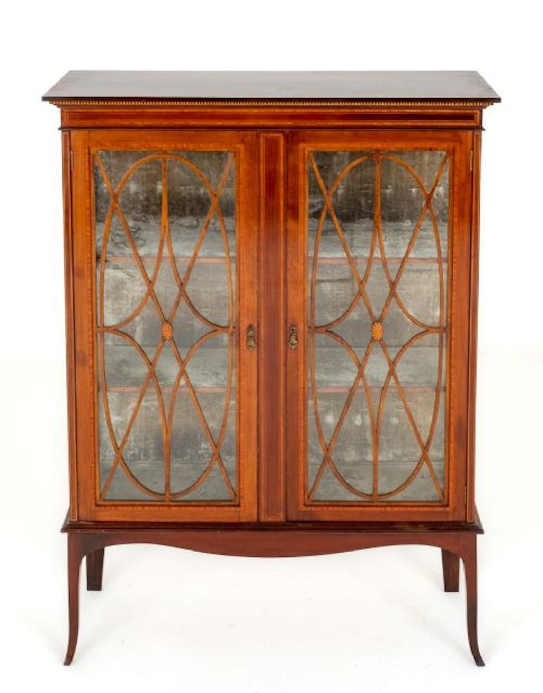 Sheraton Revival Mahogany Display Cabinet.
Circa 1890
Standing upon Shaped Legs with a Shaped Frieze.
The Cabinet Features 2 Astragal Glazed Doors Which Open to Reveal 2 Interior Shelves.
The Cabinet Has Satinwood Crossbanding and Ebony and Boxwood