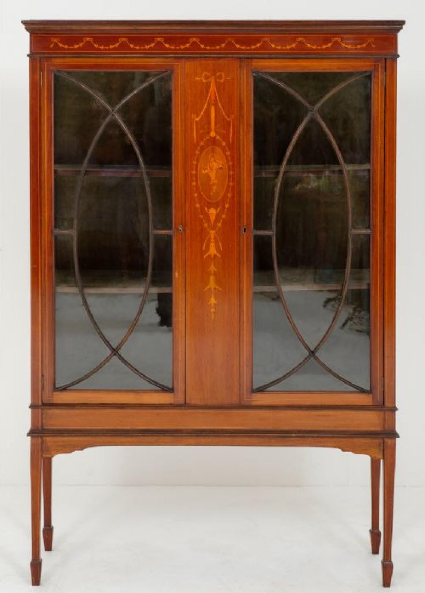 Mahogany Sheraton Revival Display Cabinet.
Standing on tapered legs with spade feet.
circa 1880
This piece has a central Marquetry panel, 2 x glazed doors with original locks and key.
In excellent condition.