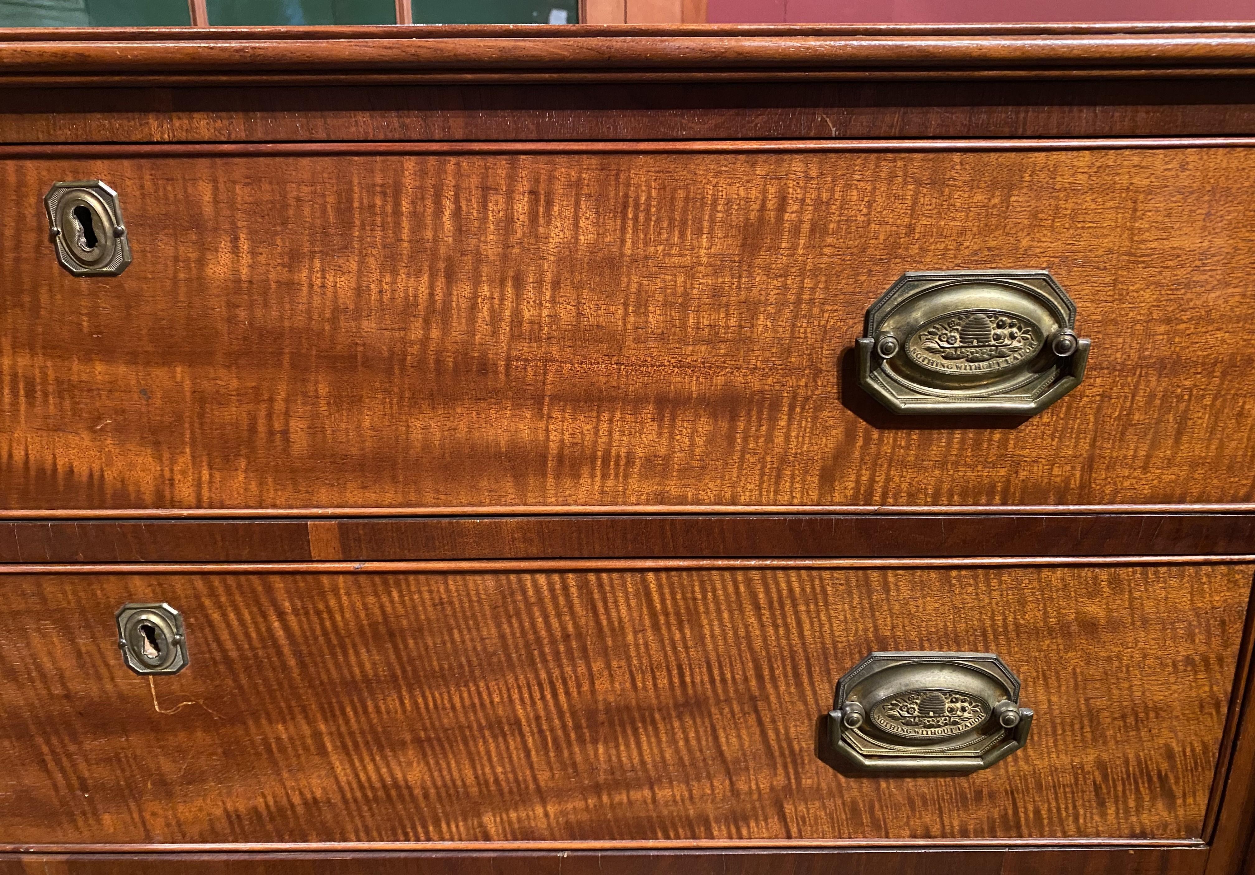 A fine Sheraton Federal period cherry and mahogany four drawer chest, its rectangular top with turret corners surmounting a case with four long beaded drawers with tiger maple fronts with decorative octagonal beehive brasses which read “Nothing