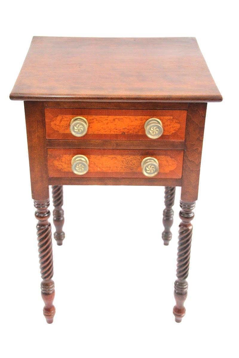 Figured birch, bird’s-eye maple, and mahogany work table, the square birch case possessing two drawers with brass pulls fitted with bird’s-eye maple panels. The top drawer contains compartmentalized tray. Table rests above four rope-twisted mahogany