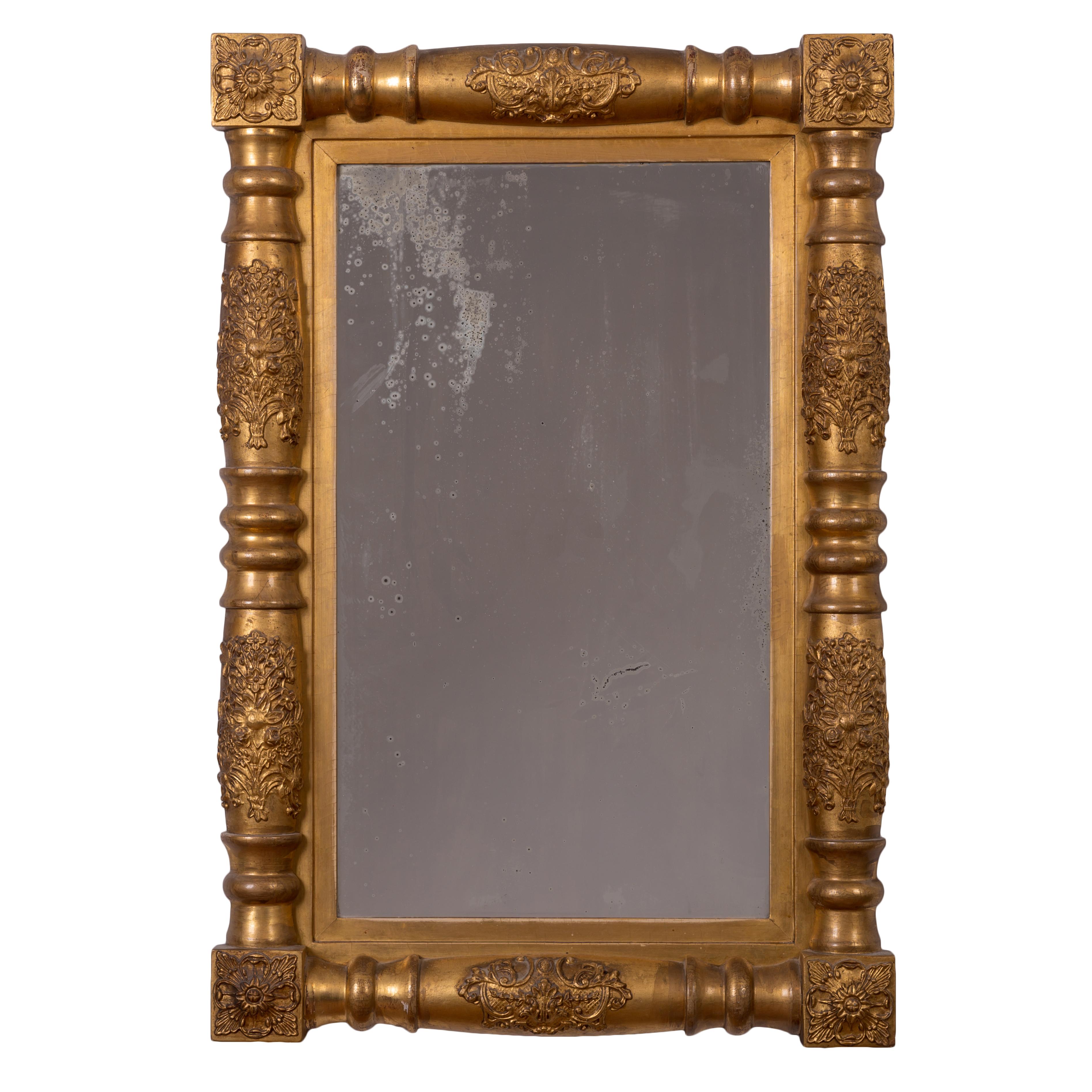 A Sheraton giltwood mirror, circa 1830.
Antique plate; original gilding with some early retouching.

23 inches wide by 34 inches tall by 3 inches deep