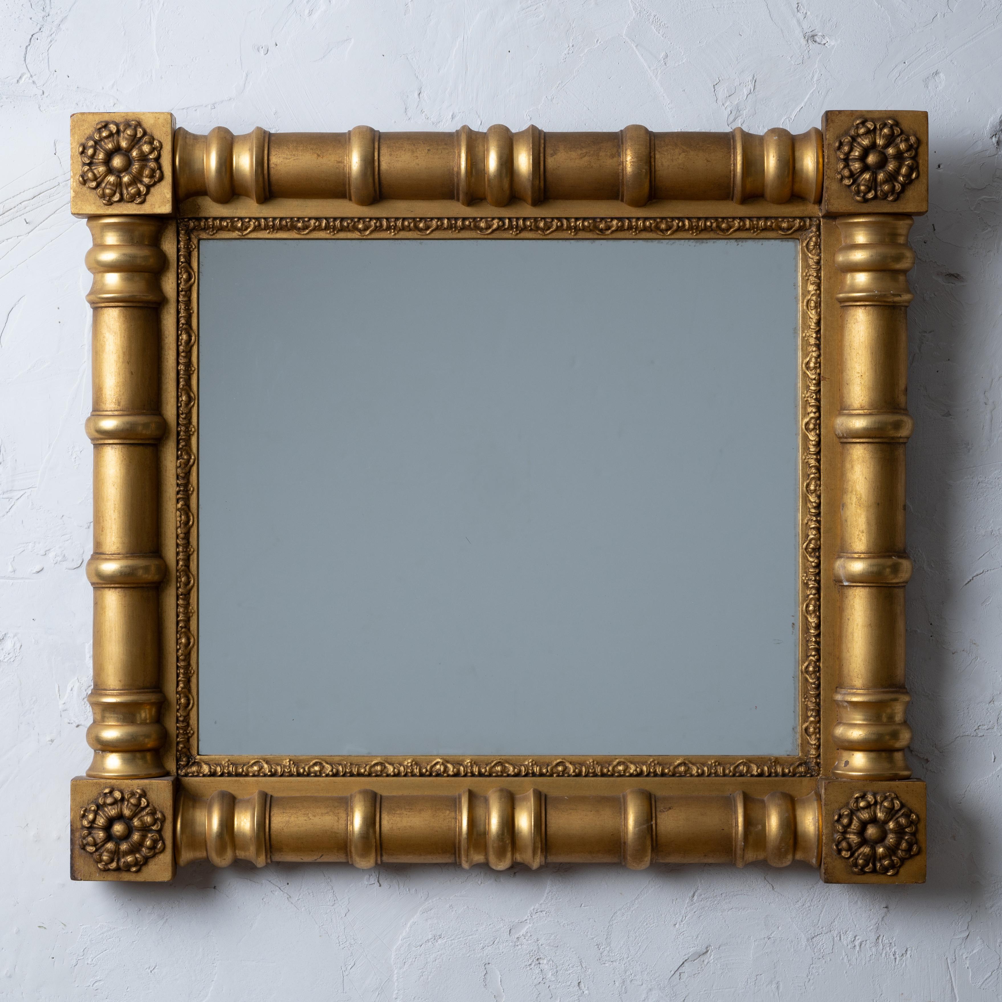 A Sheraton giltwood mirror, circa 1830.
A split baluster frame with rosette corner blocks.

30 by 26 ¾ inches 

