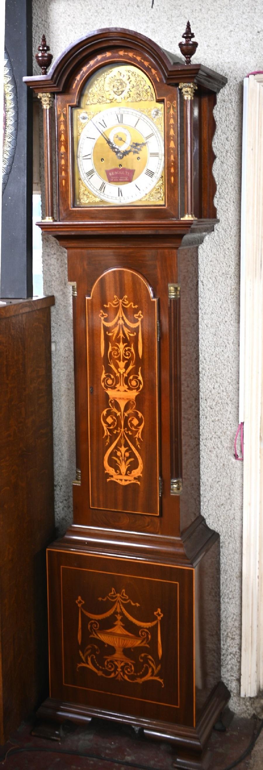 Glorious Sheraton Revival grandfather clock in mahogany
Features intricate inlay work including urns, scrolls and floral motifs to great affect
Gorgeous brass face with a sun motif and the plaque marked 'Resolute'
Surmounted by two classical urn