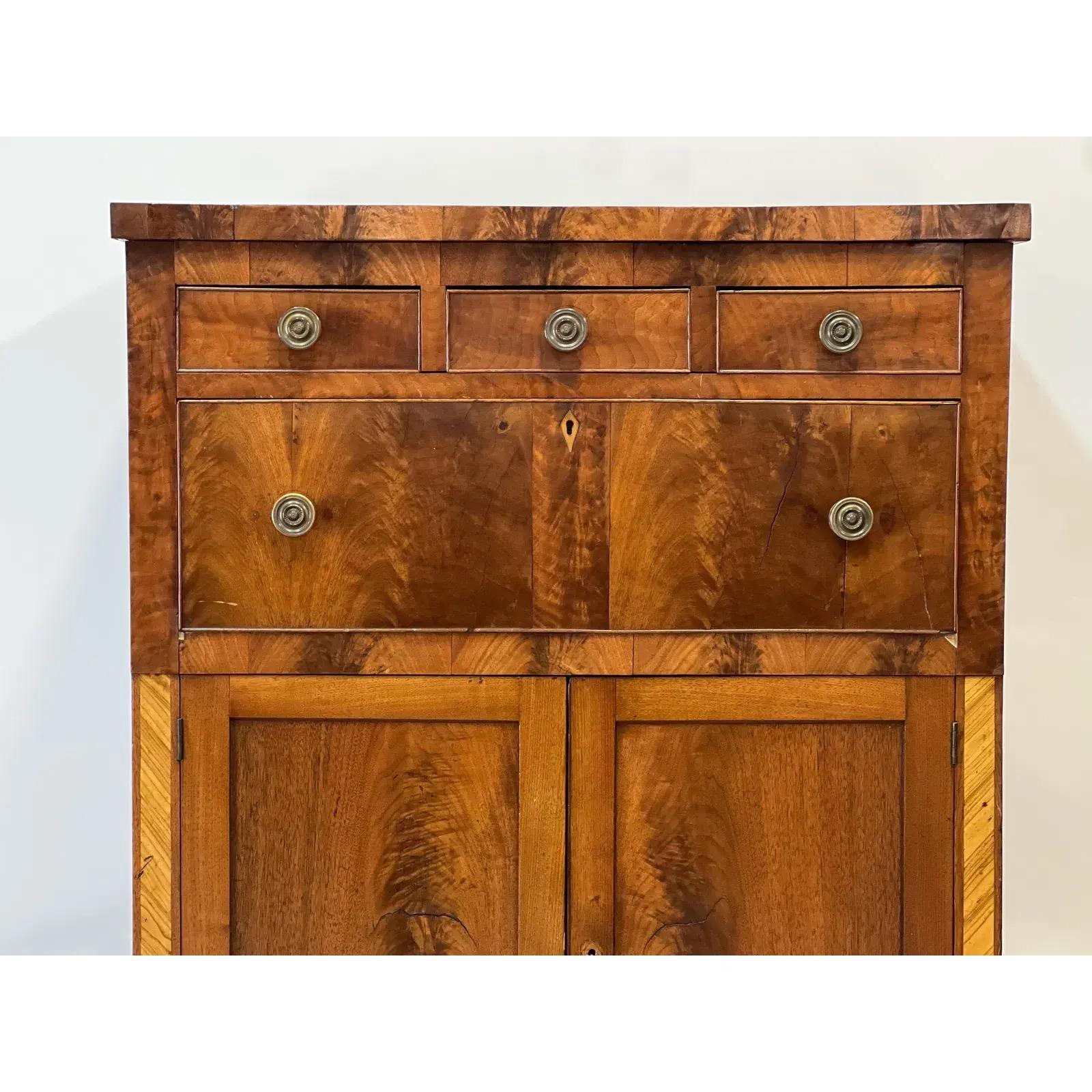 A Sheraton mahogany cabinet with three shallow over one large drawer and a cupboard base. Raised on turned legs.

Dimensions
37ʺW × 20.5ʺD × 59.5ʺH