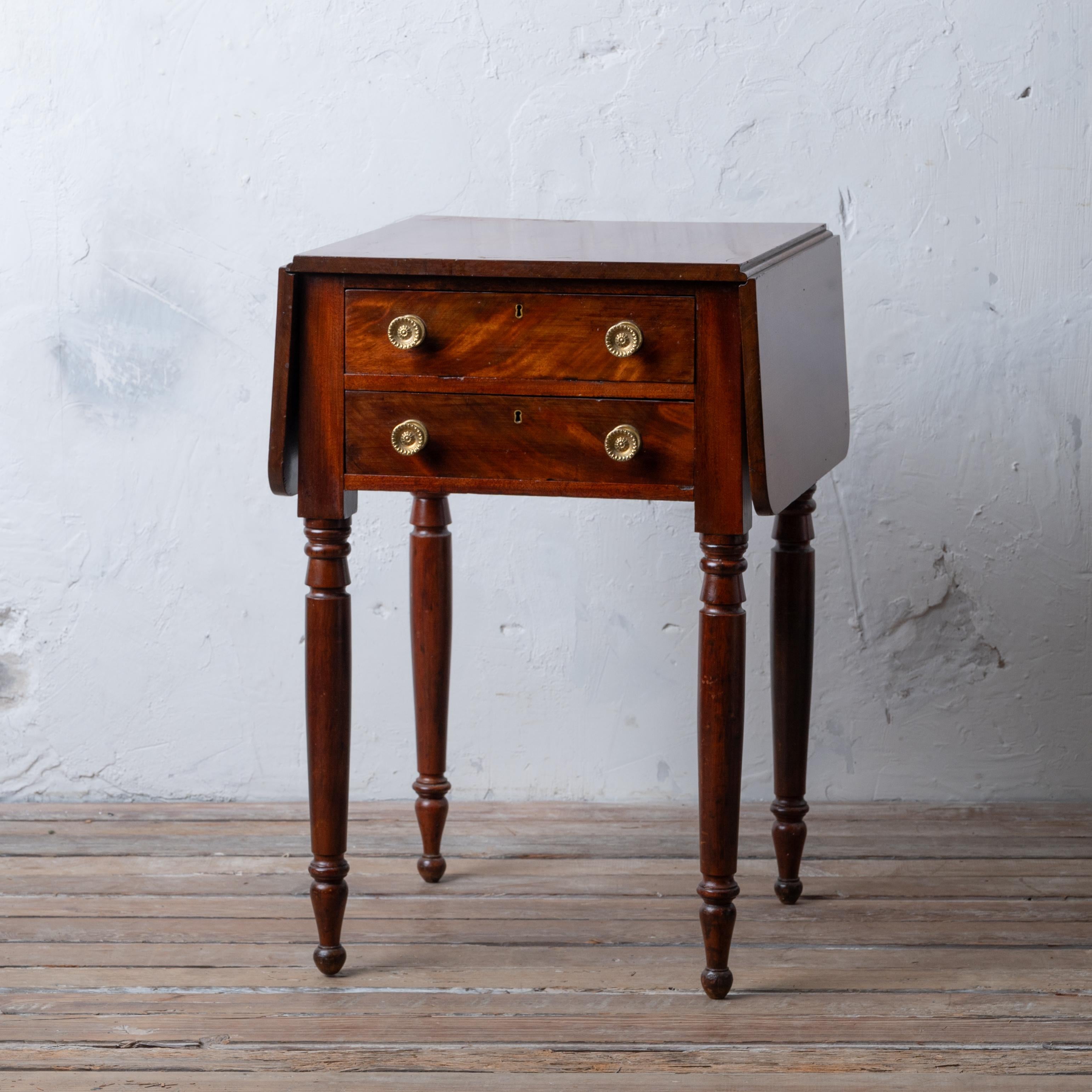 A Sheraton Mahogany two drawer drop leaf work table, American, circa 1830s.

19 ½ inches wide by 18 ½ inches deep by 29 inches tall; leafs extended, 36 ¼ inches

