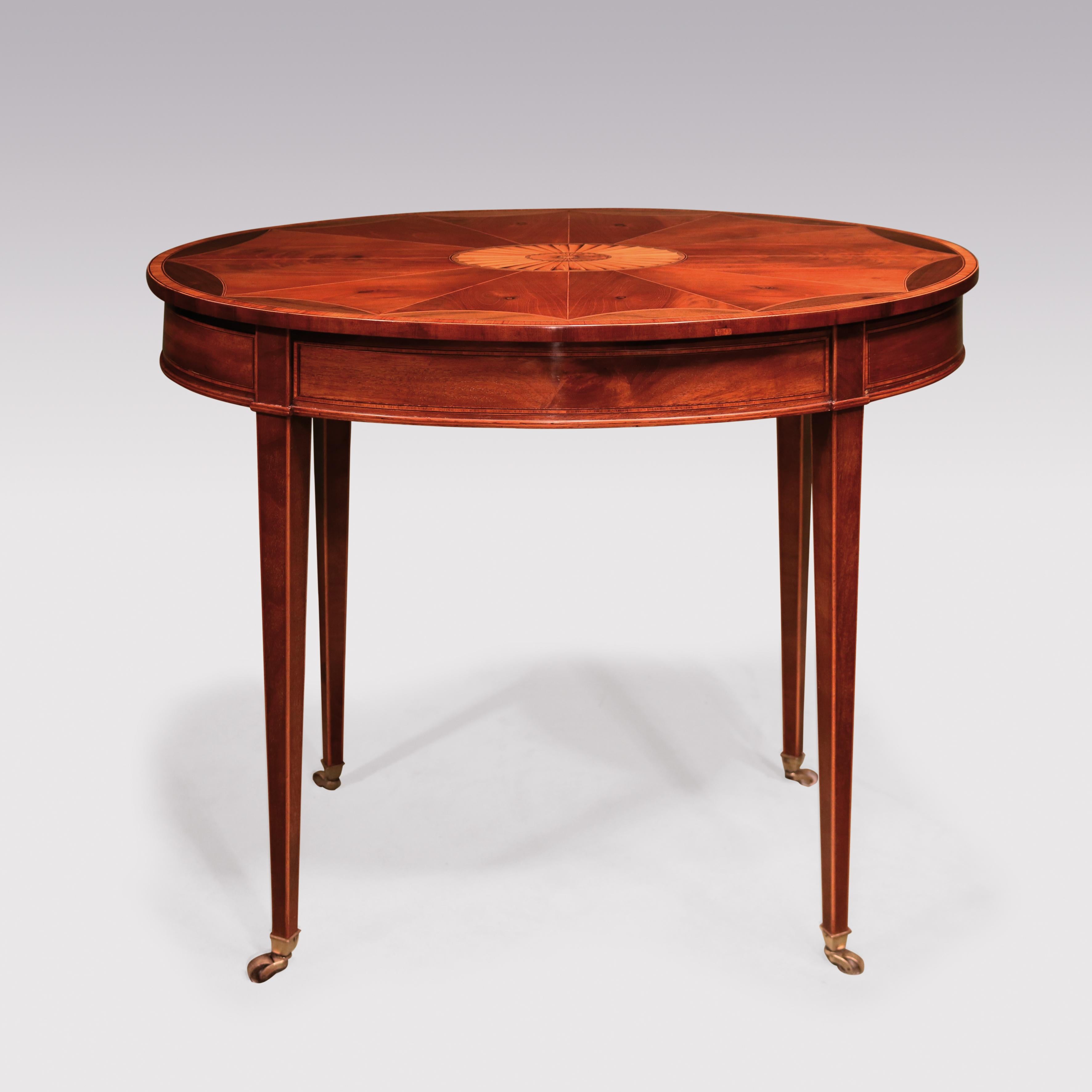 A late 18th century Sheraton period mahogany occasional table, boxwood and ebony strung throughout, having oval segmented top with central fan inlay, supported on square tapering legs ending on brass box castors.