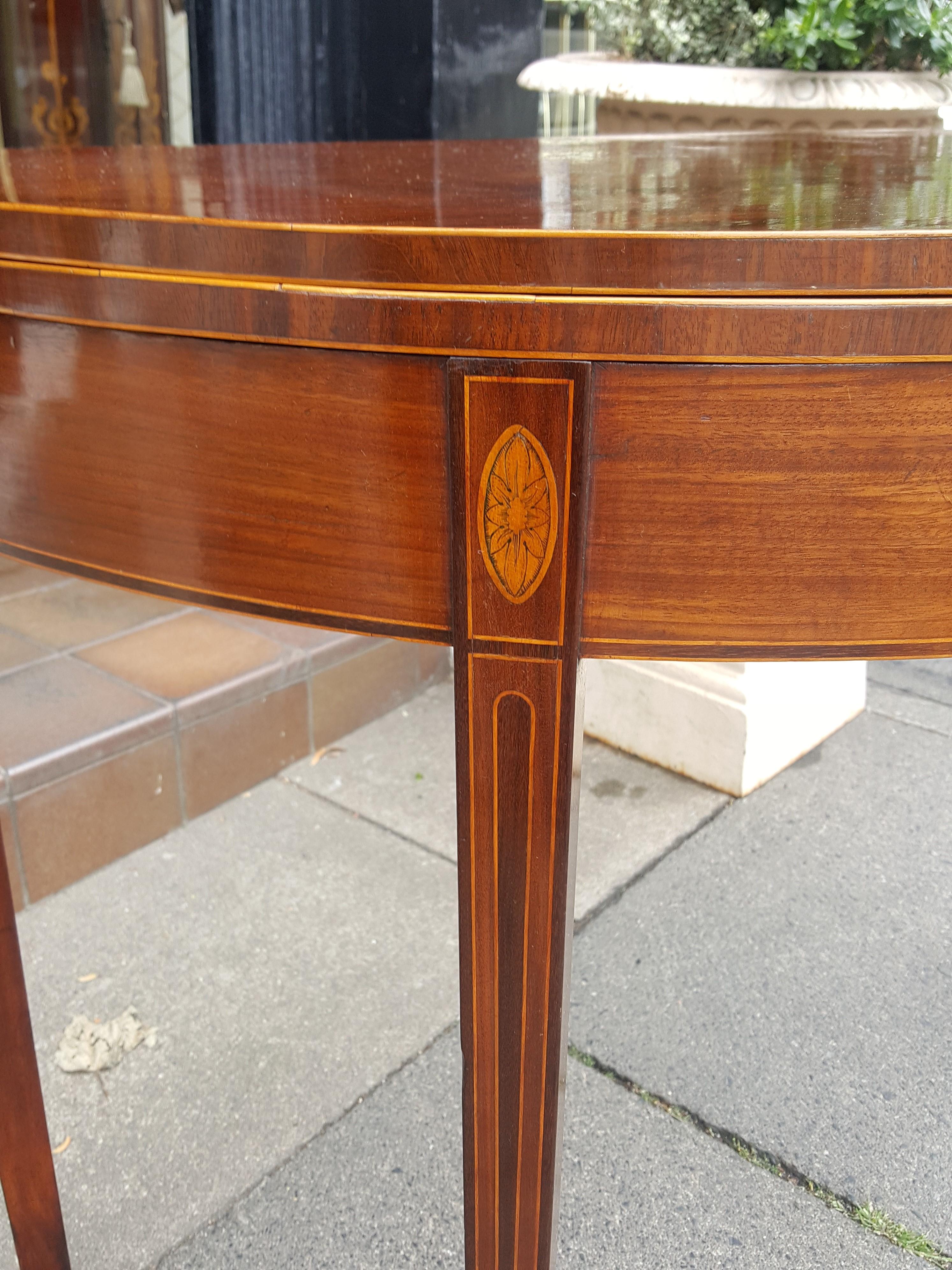Sheraton period Mahogany demilune tea table with square tapered inlaid leg and double gate action.
Measures: 35