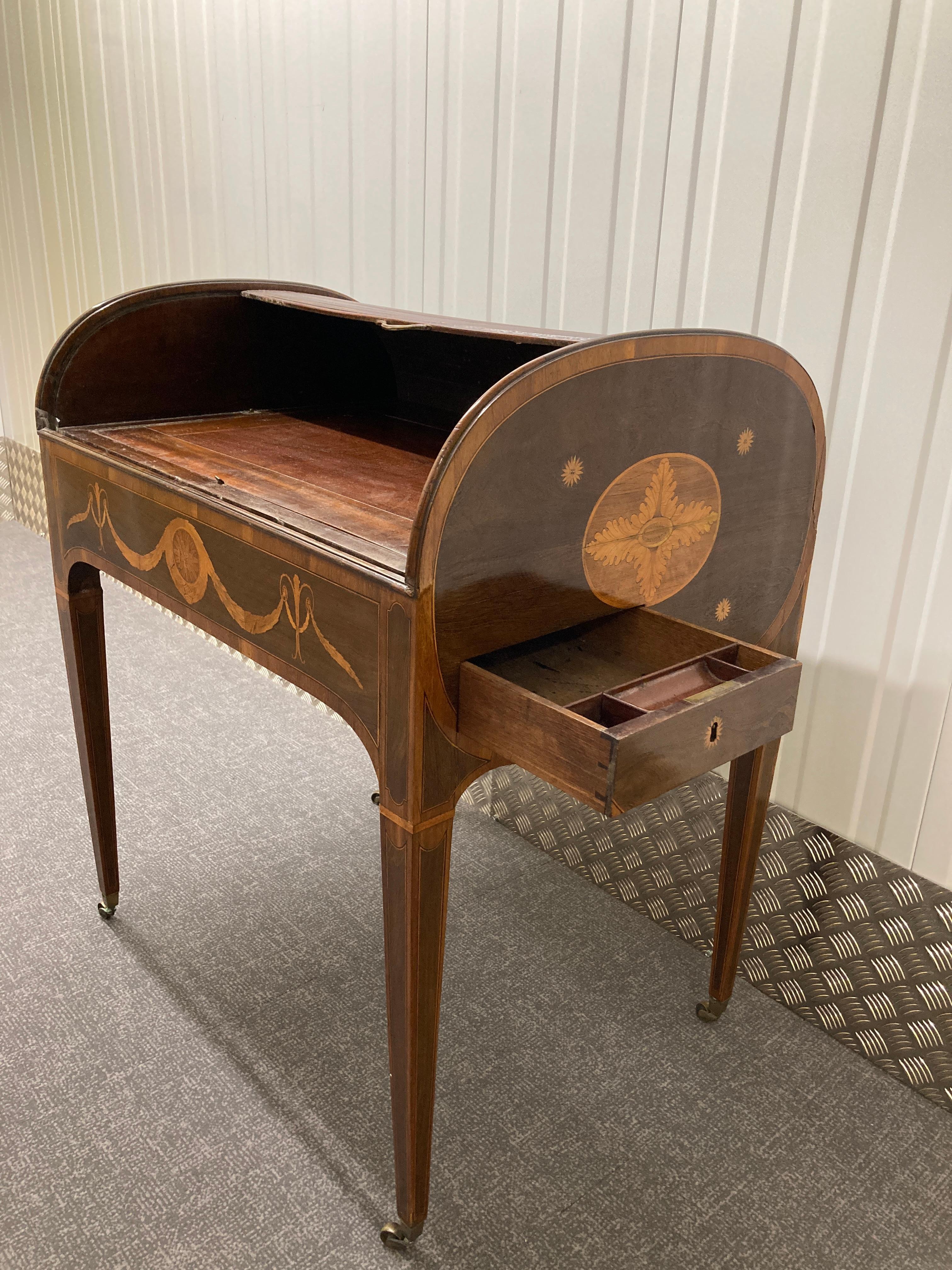 Sheraton period partridigewood desk, completely enclosed by reeded tambour shutter, a short draw to each side, on square tapering legs, the whole inlaid with floral marquetry panels crossbanding and lines, 31 inches wide.