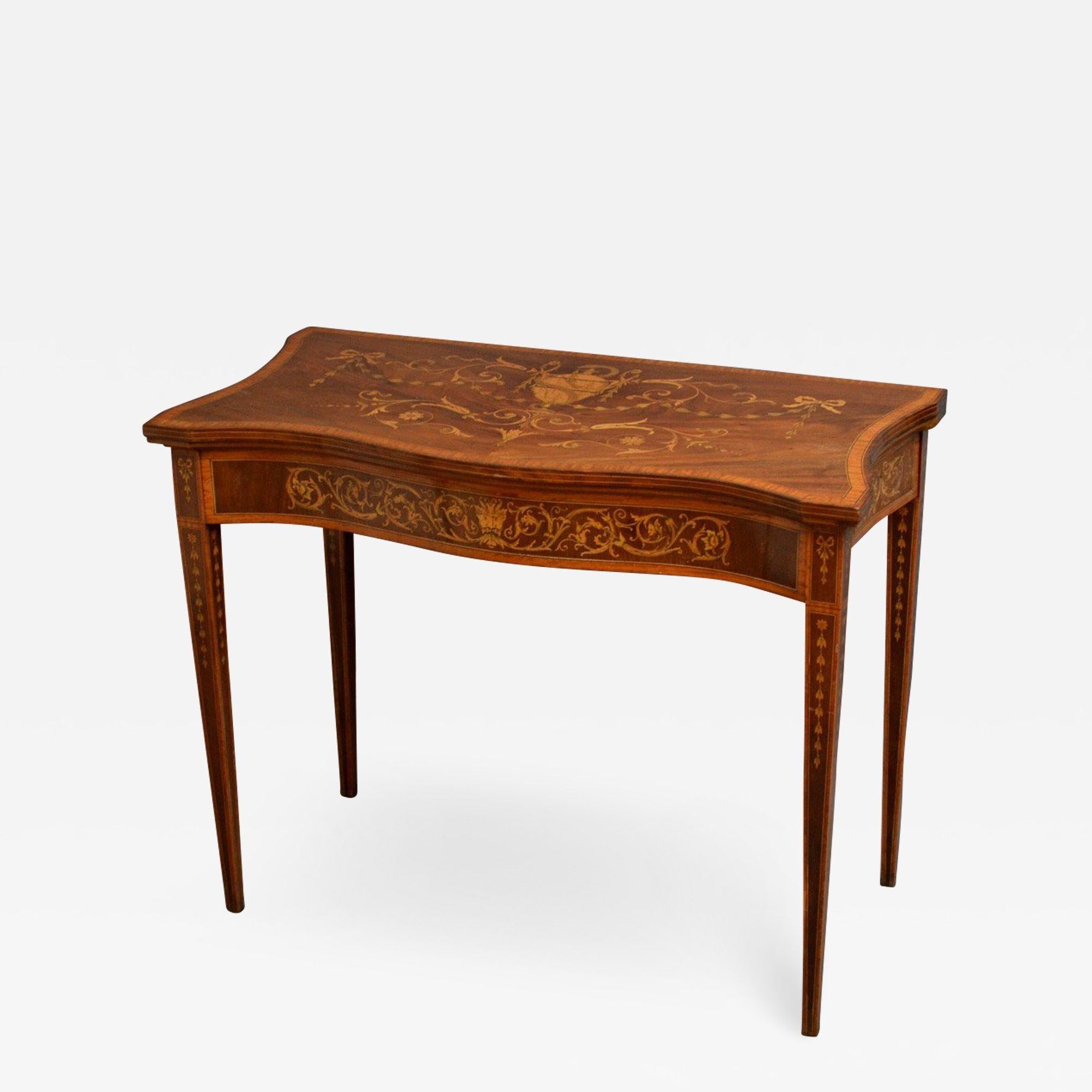 Sn4384 Edwardian Sheraton Revival mahogany and inlaid card table, having finely inlaid serpentine top enclosing green baize games surface, above inlaid and crossbanded frieze, standing on tapered inlaid and crossbanded legs. This antique games table