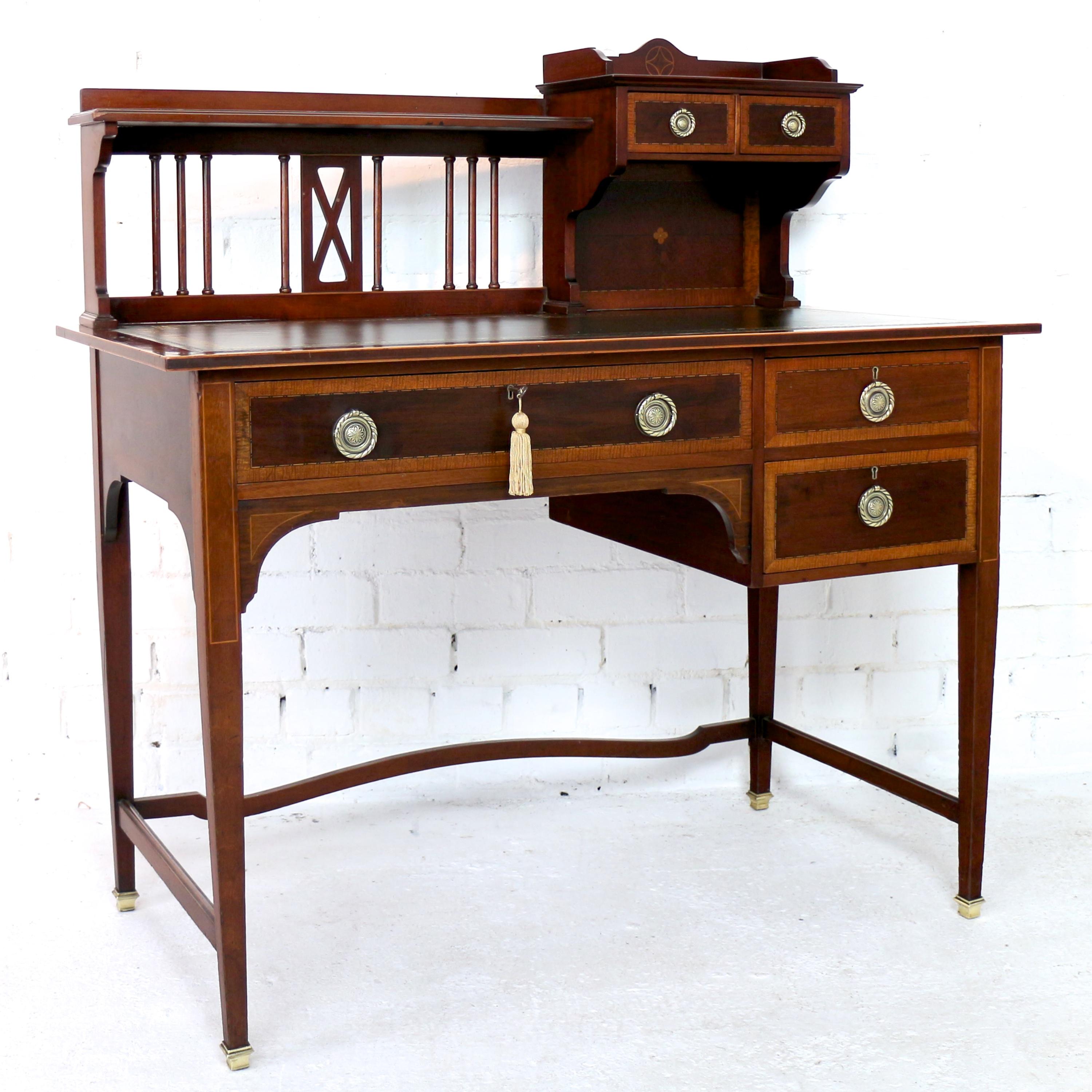 A lovely Sheraton revival mahogany and inlaid writing desk attributed to Shapland & Petter of Barnstaple and dating to circa 1900. With satinwood crossbanding and box and ebony line inlays it features a superstructure with Arts & Crafts influenced