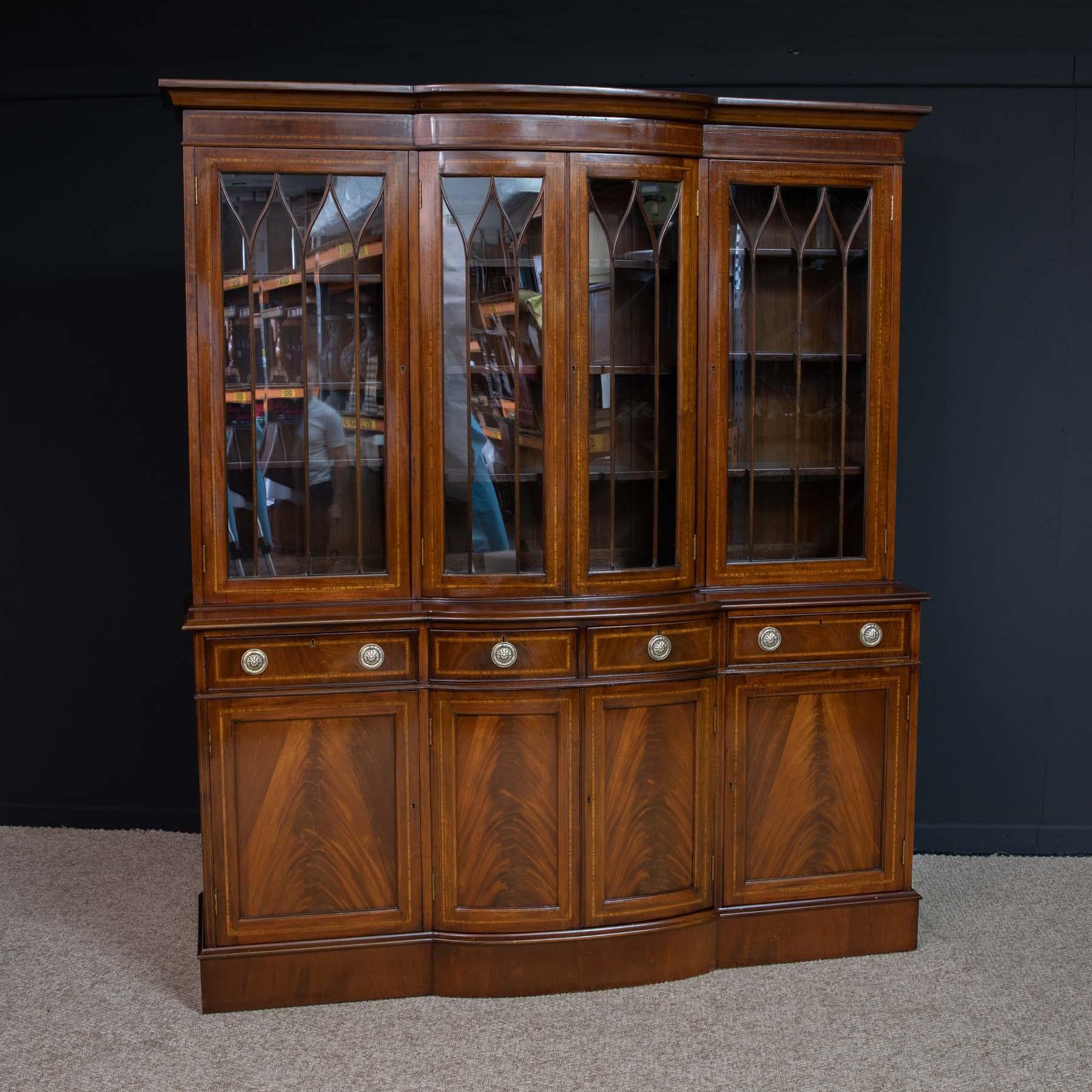 Mid-20th century mahogany bookcase in the Sheraton style. This is of excellent craftsmanship and quality. The central section is bow-fronted and the whole piece is cross-banded with satinwood and ebony. All keys and locks are working and the