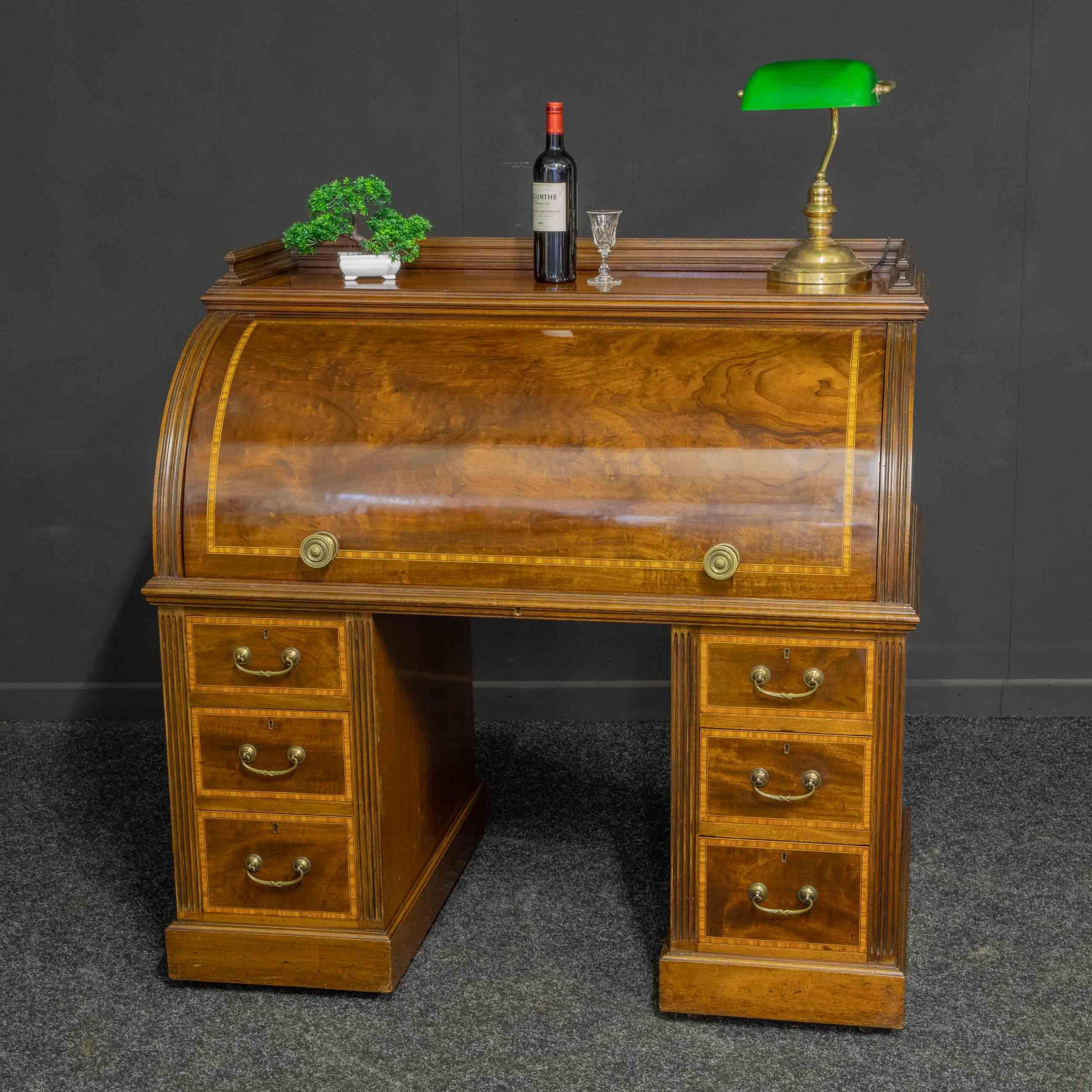 Superbe bureau à cylindre en acajou de style Sheraton de la fin de l'époque victorienne, de proportions attrayantes. La base comporte une paire de piédestaux à trois tiroirs, tous dotés d'une belle bande transversale en bois de satin et d'ébène, qui