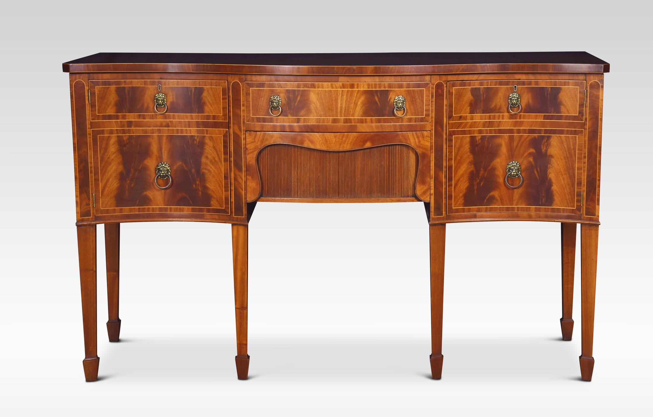 Mahogany and string inlaid sideboard, the large rectangular well-figured serpentine fronted top. Above two central frieze drawers flanked by faux drawer cupboards. All raised up on tapering square legs and spade feet.
Dimensions
Height 36