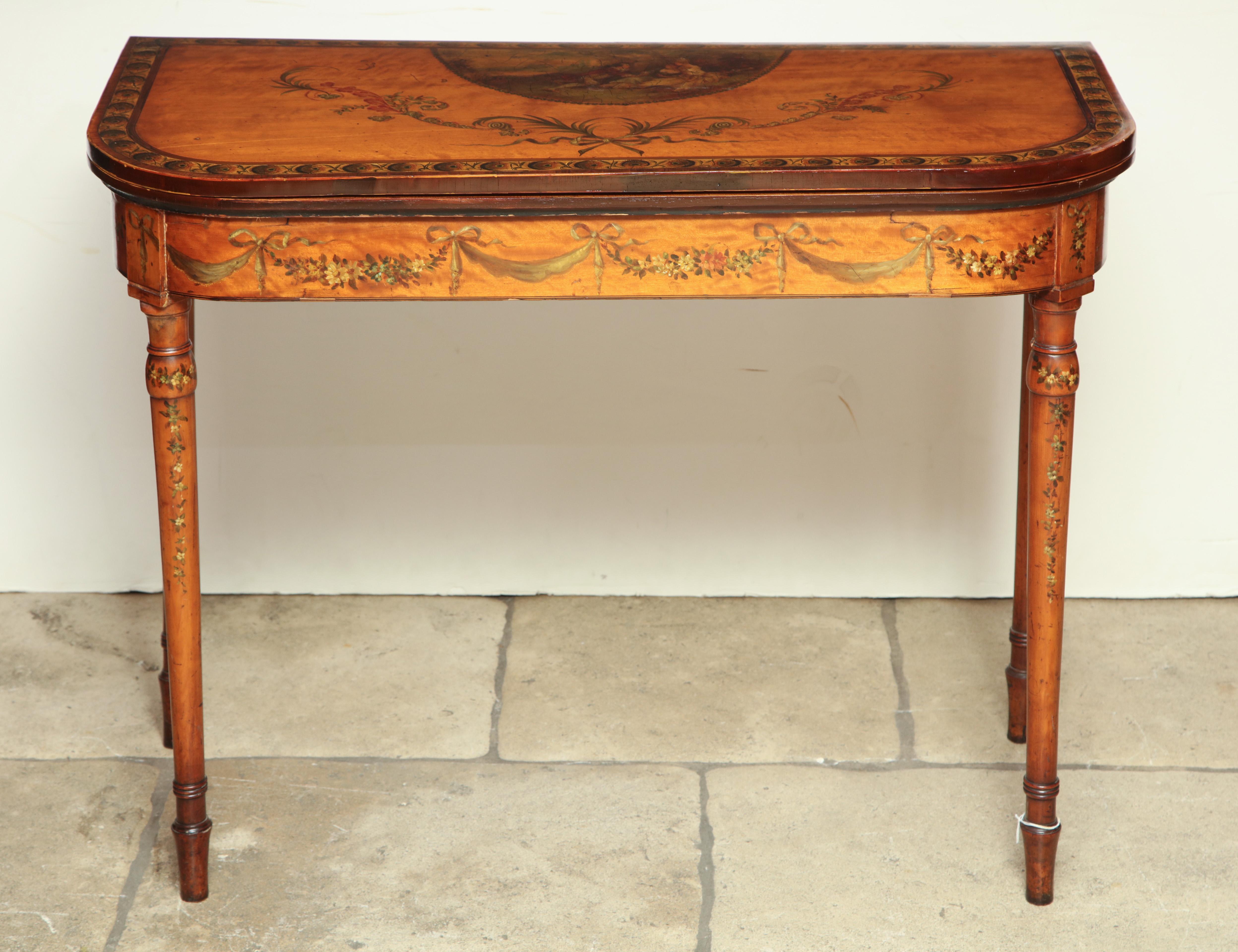 A fine English Sheraton satinwood crossbanded game table with hand painted neoclassic decorations on turned and tapaered legs.