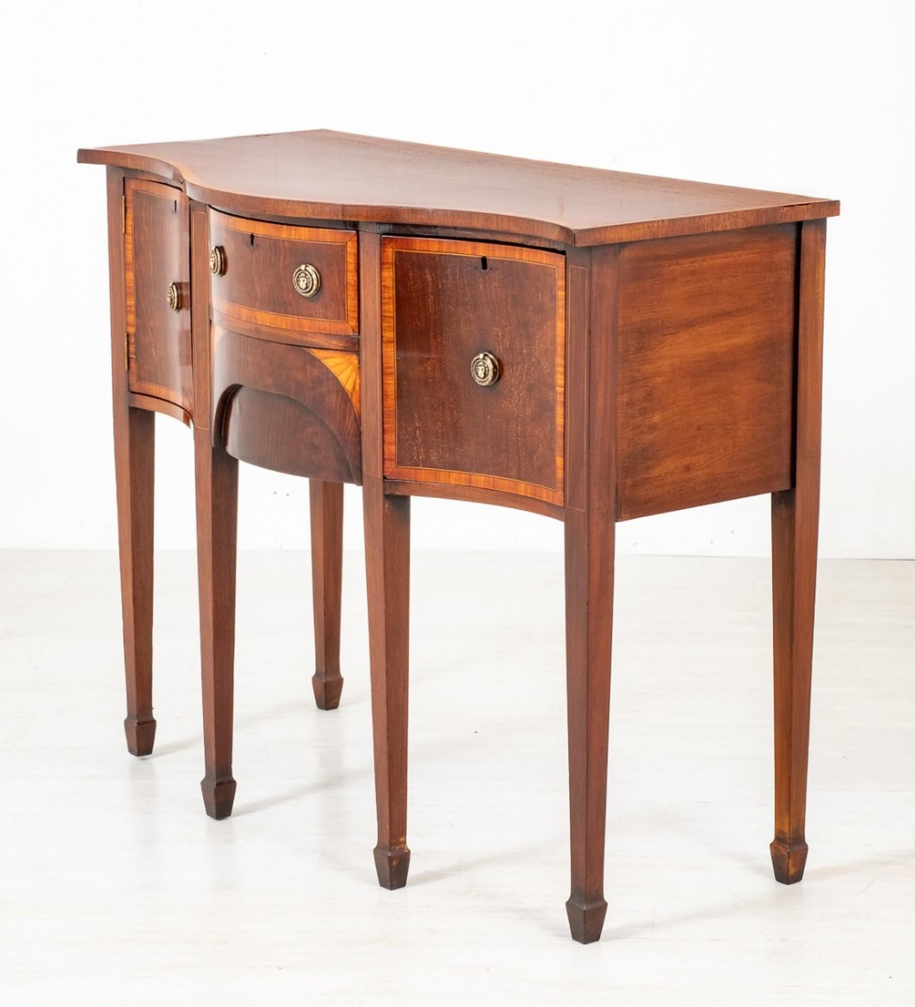 This Pretty mahogany Sheraton Revival Serpentine sideboard standing upon 6 Tapered Legs with Spade feet.
circa 1860
Featuring an arrangement of 3 Oak Lined Drawers (note the quality dovetails) and 1 Cupboard.
The Lower Central Drawer Features