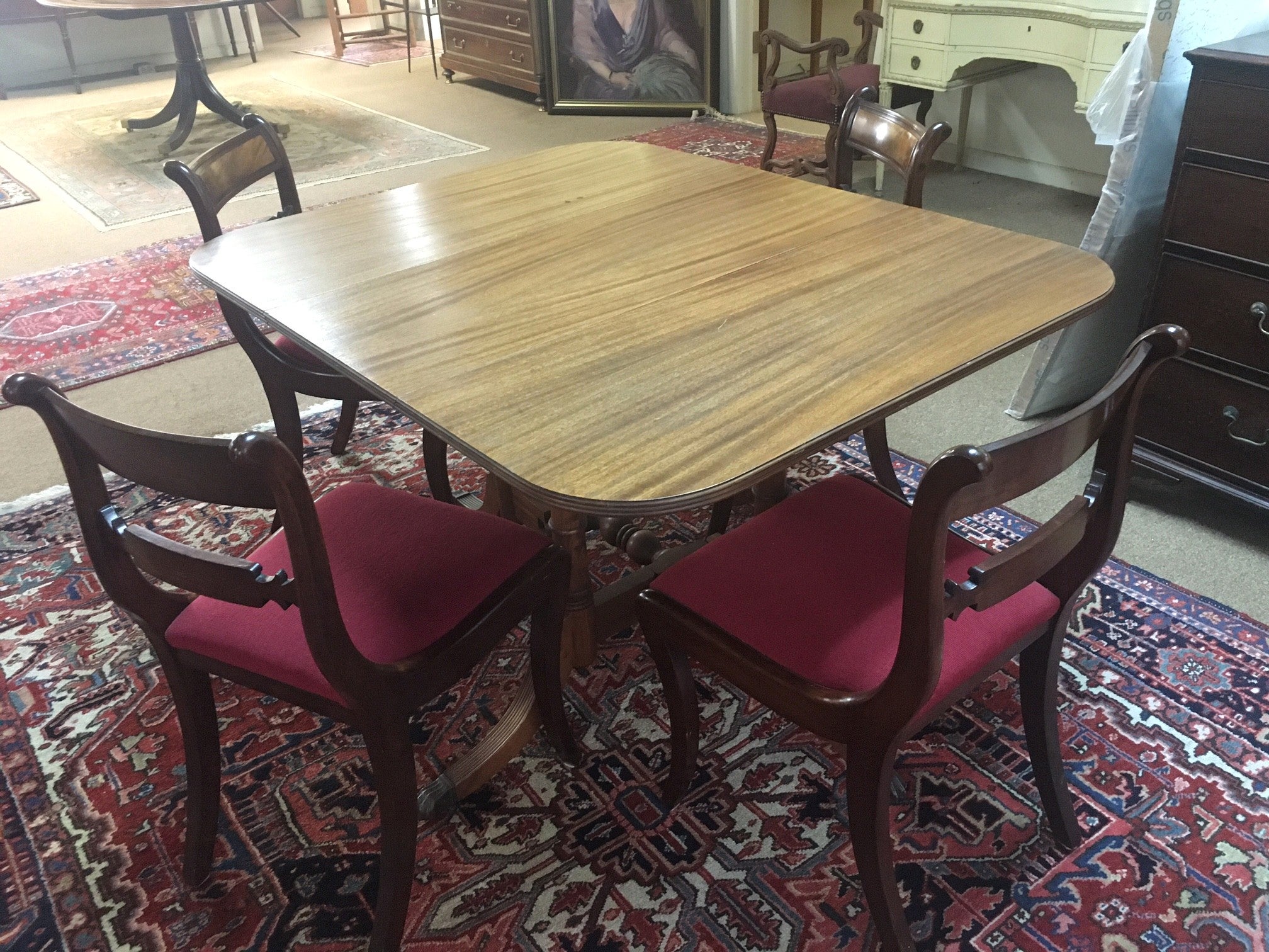 Cette table de salle à manger unique de style Sheraton en acajou est dotée de pieds pivotants, ce qui est parfait si vous avez besoin de plus d'espace de temps en temps, et de pieds cannelés avec des roulettes en laiton. Quatre belles chaises à