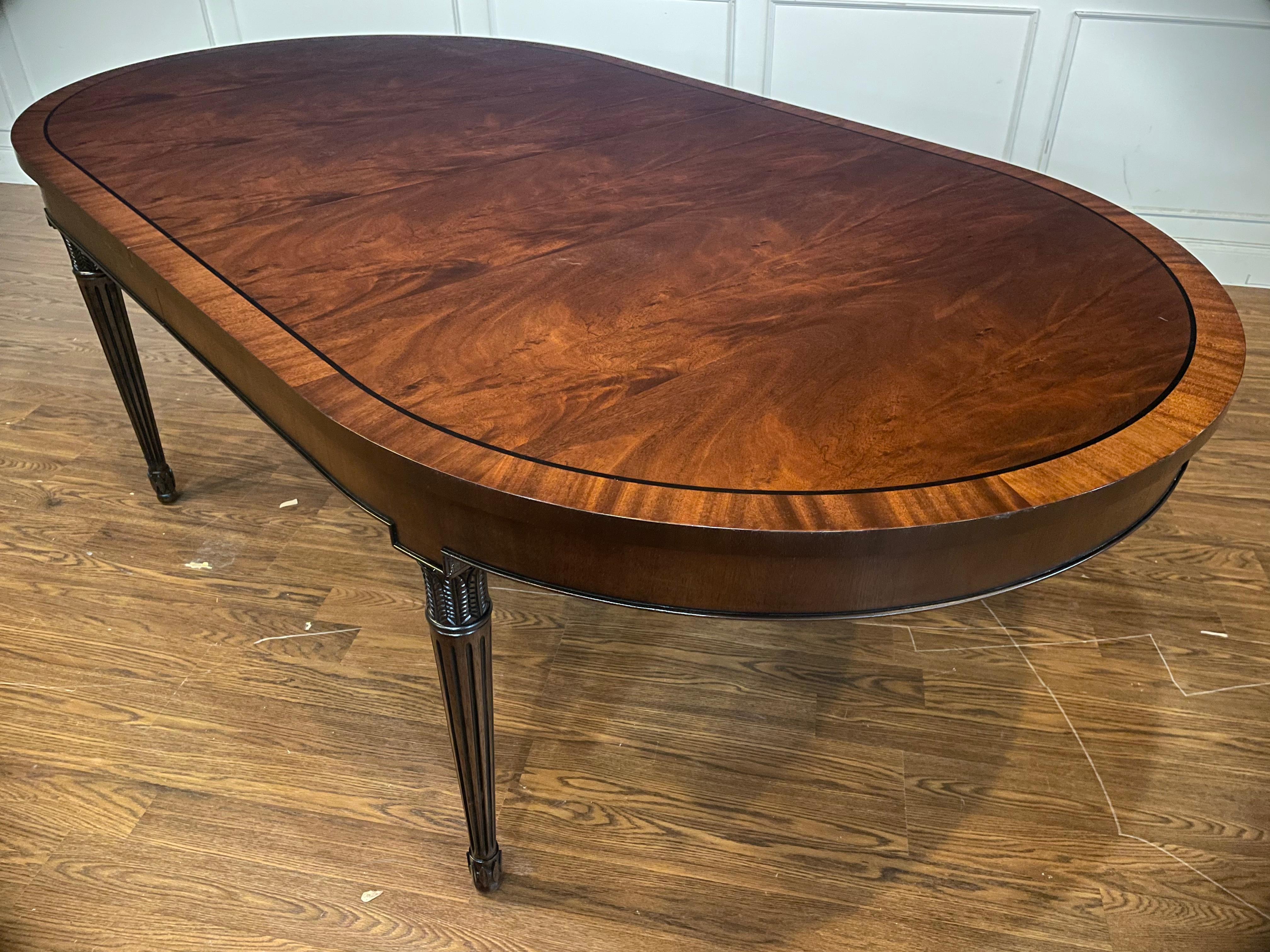 This table features and oval shape with a swirly crotch mahogany field, straight grain mahogany border and classic Sheraton style round fluted and tapered legs. It has a hand rubbed and polished semigloss sheen. 

Dimensions: Width=48”,
