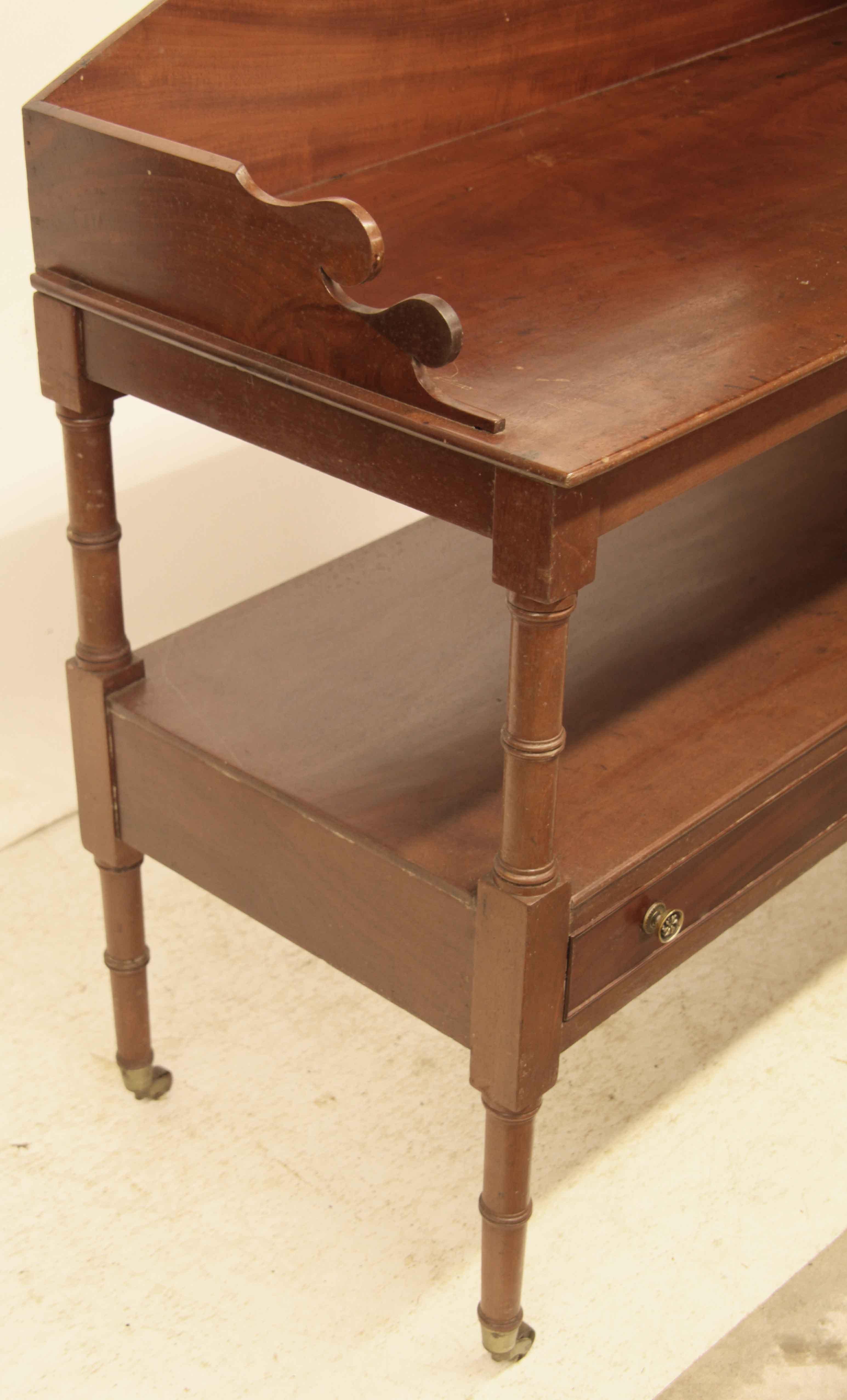 Sheraton two drawer serving table , with bow back gallery,  the top has beautiful mahogany grain,  lower shelf above two drawers,  legs have faux bamboo turnings and terminate with brass cup castors.   The surface height is 32.5'' .   
