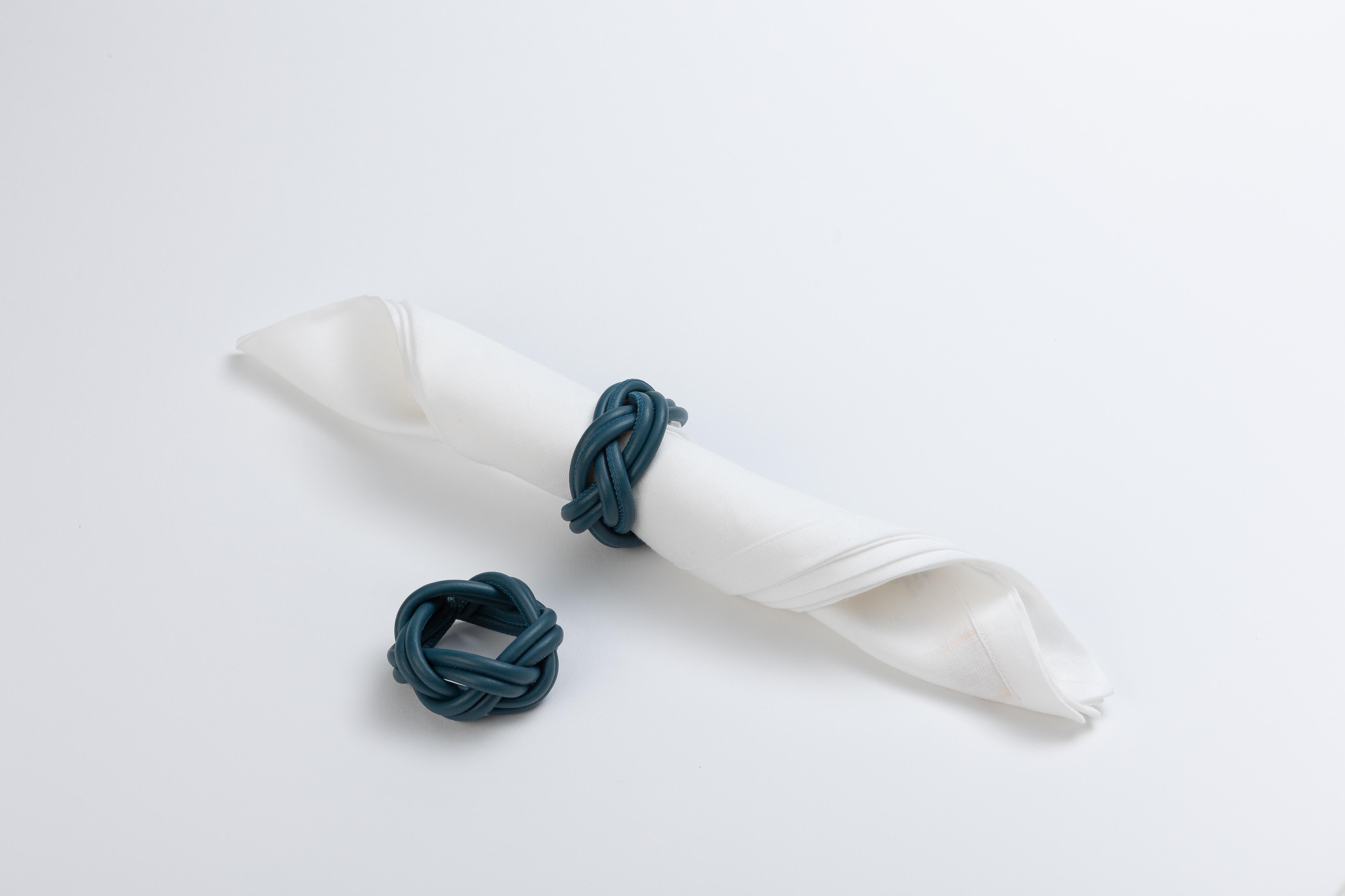 Este exquisito servilletero, eco de un objeto cotidiano, eleva cualquier mesa con su encanto y equilibrio visual. El objeto está hecho de cuero con un sistema de ribeteado, en el que finas tiras de cuero fino se entretejen para crear un mueble