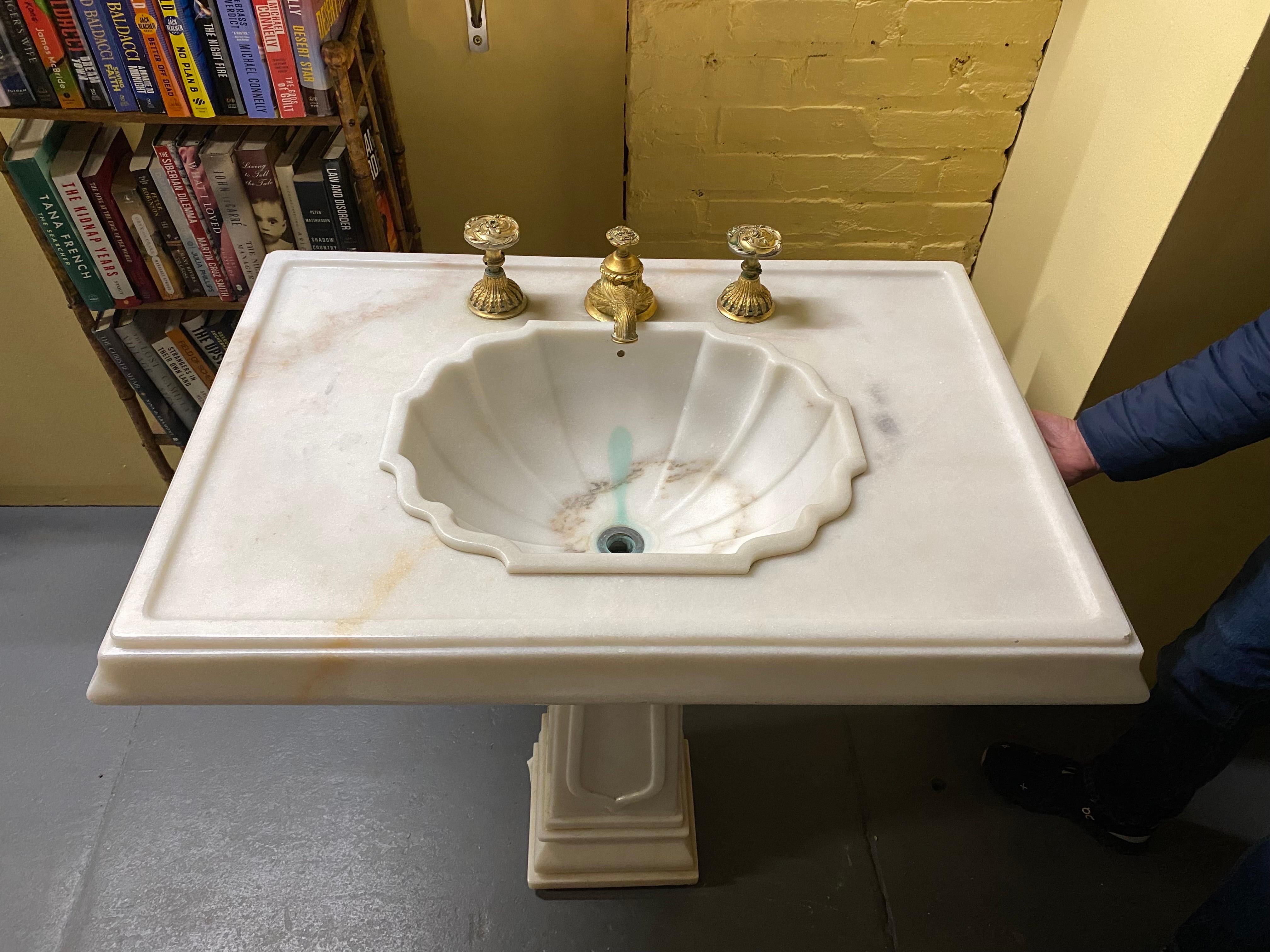 Sherle Wagner pedestal sink with brass Faucets. This sink dates to the 1990's, in overall good condition. Sink bowl shows pale green coloring from water. The brown ring is the marbling of the stone. A little edge wear but no chips or cracks. Top