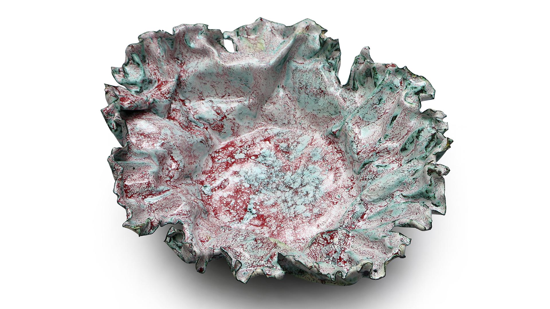 This custom shaped bowl has an organic flow with edges that have been carefully sculpted to add a visual interest to the shape. The red color has been gently dappled on to a white layer, creating many hues of reds.