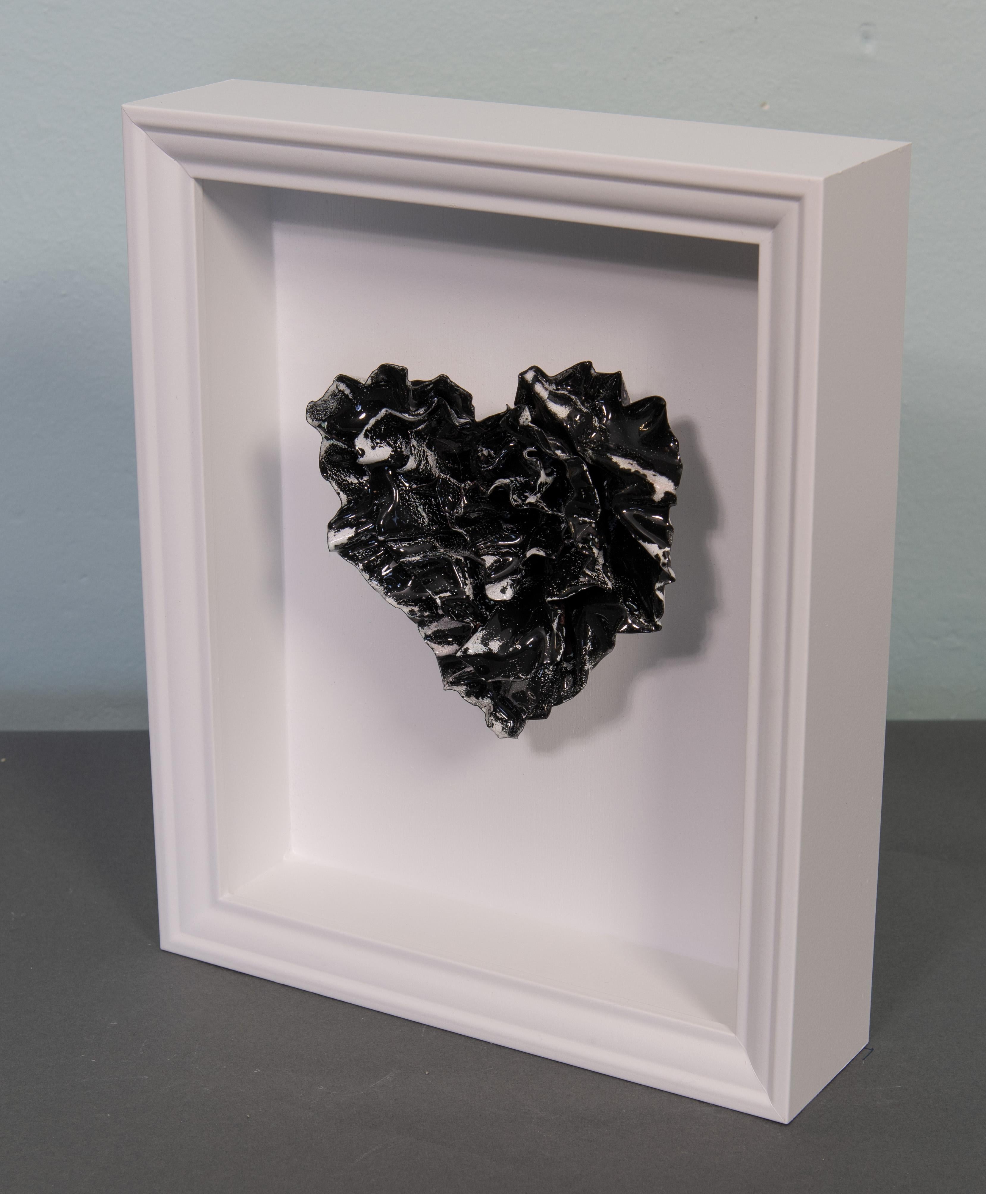 Unforgotten Heart is a stunning abstract heart sculpture by artist Sherry Been.
This metal sculpture features a striking contrast of black and white enamel, symbolizing the struggle between visibility and invisibility. Each stroke of color tells a