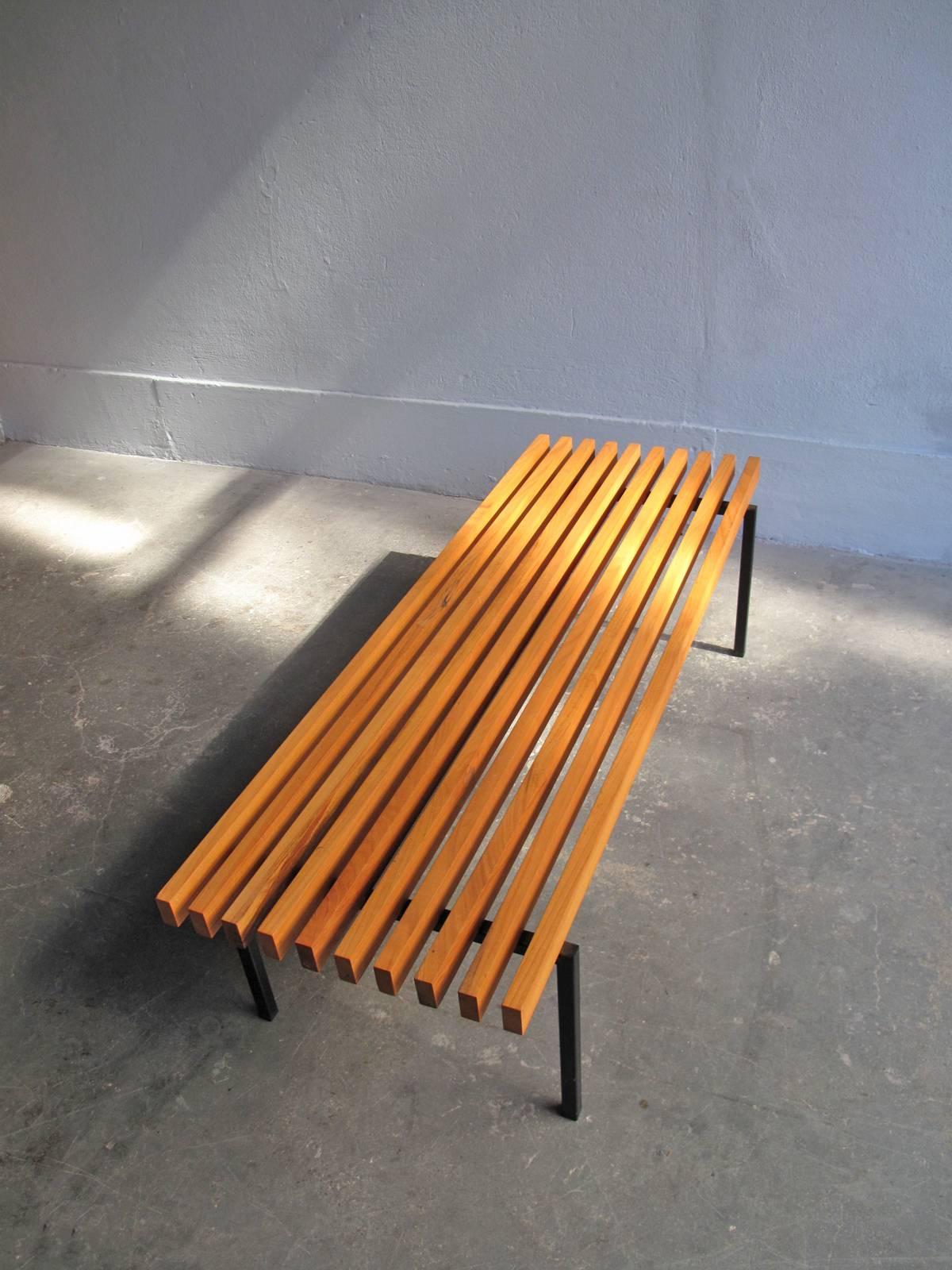 Sherry wood bars in a black lacquered metal base bench.