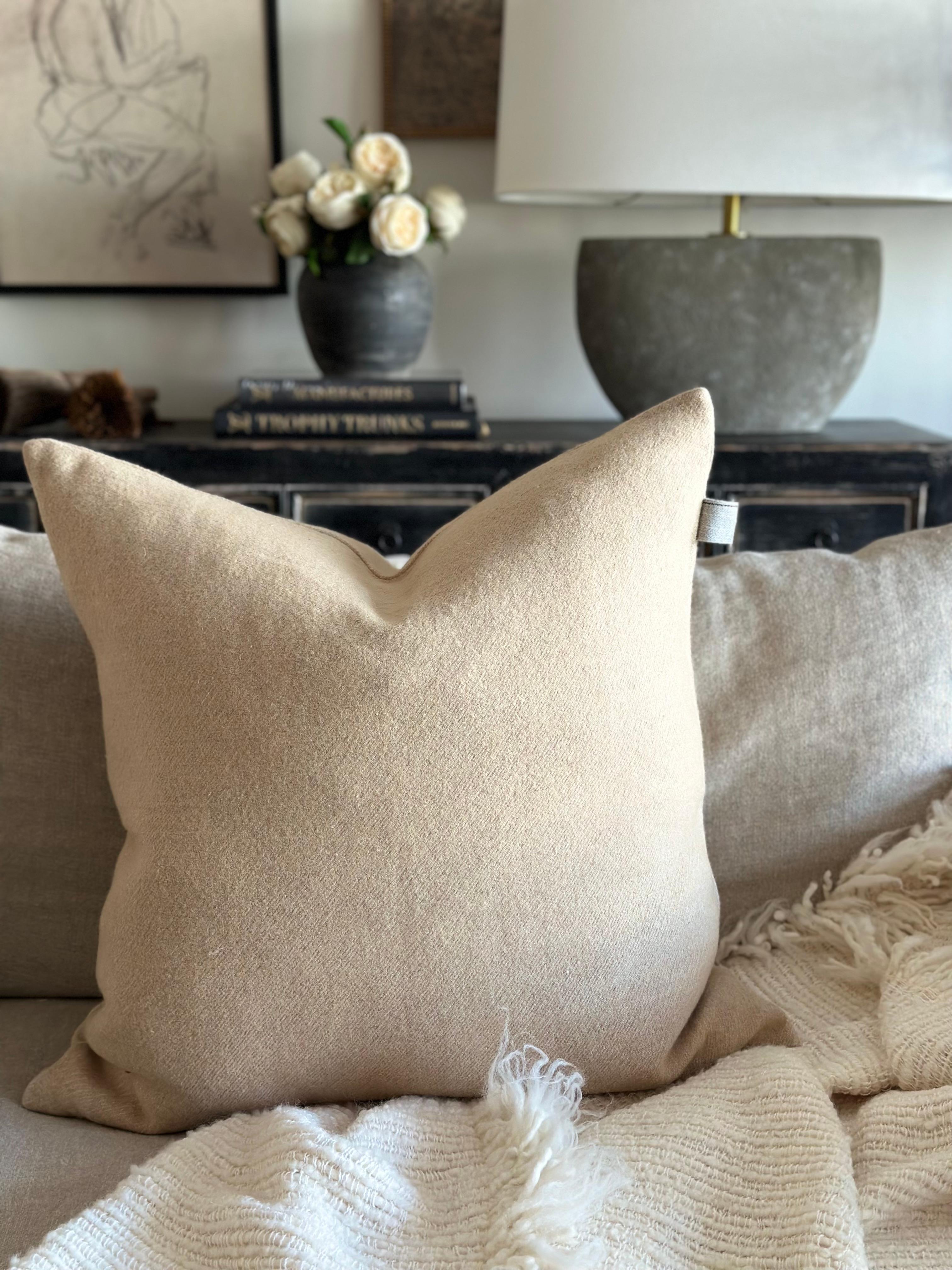 The combination of linen and wool makes for an extra soft and warm fabric. The pillow covers are finished with a zipper and a wool trim detail. Washed finish. 
Color: Nude / Camel 
70% linen – 30% wool
Includes down / feather insert
Size: 25