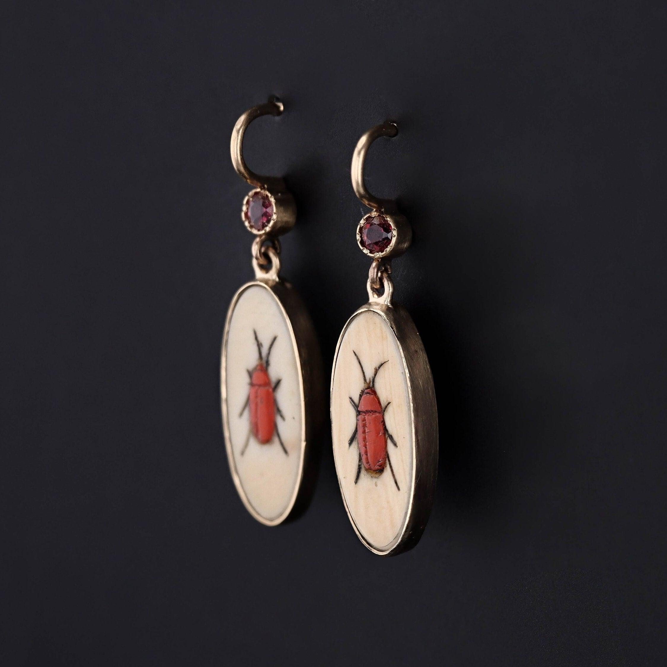 To create these earrings, our jeweler carefully cut antique shibayama game pieces (circa 1880) into an oval shape, mounted them in 14k gold, and added 14k ear wires and ruby surmounts. 

Each earring measures 1.1 inches from the top of the ear wire