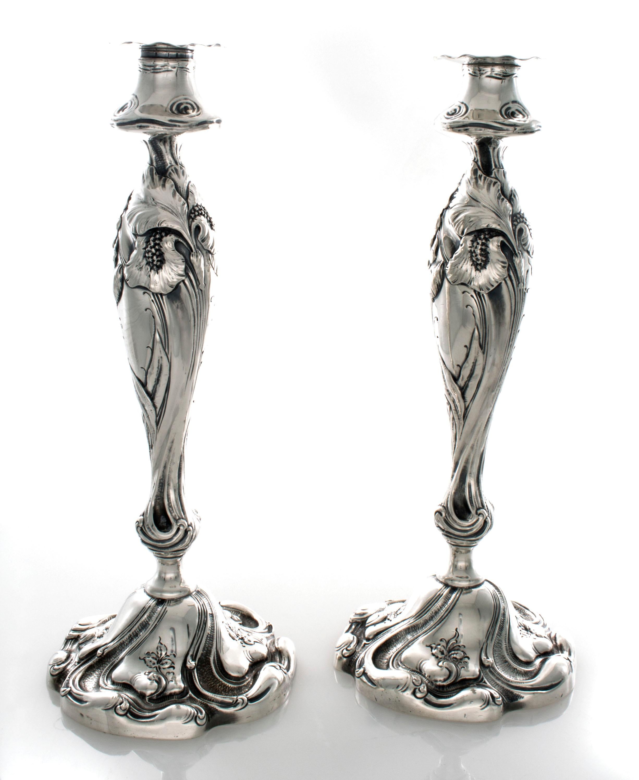Goerge Shiebler candlesticks with a deep design of irises. They have a 3 letter monogram MGH. They are 11 1/4