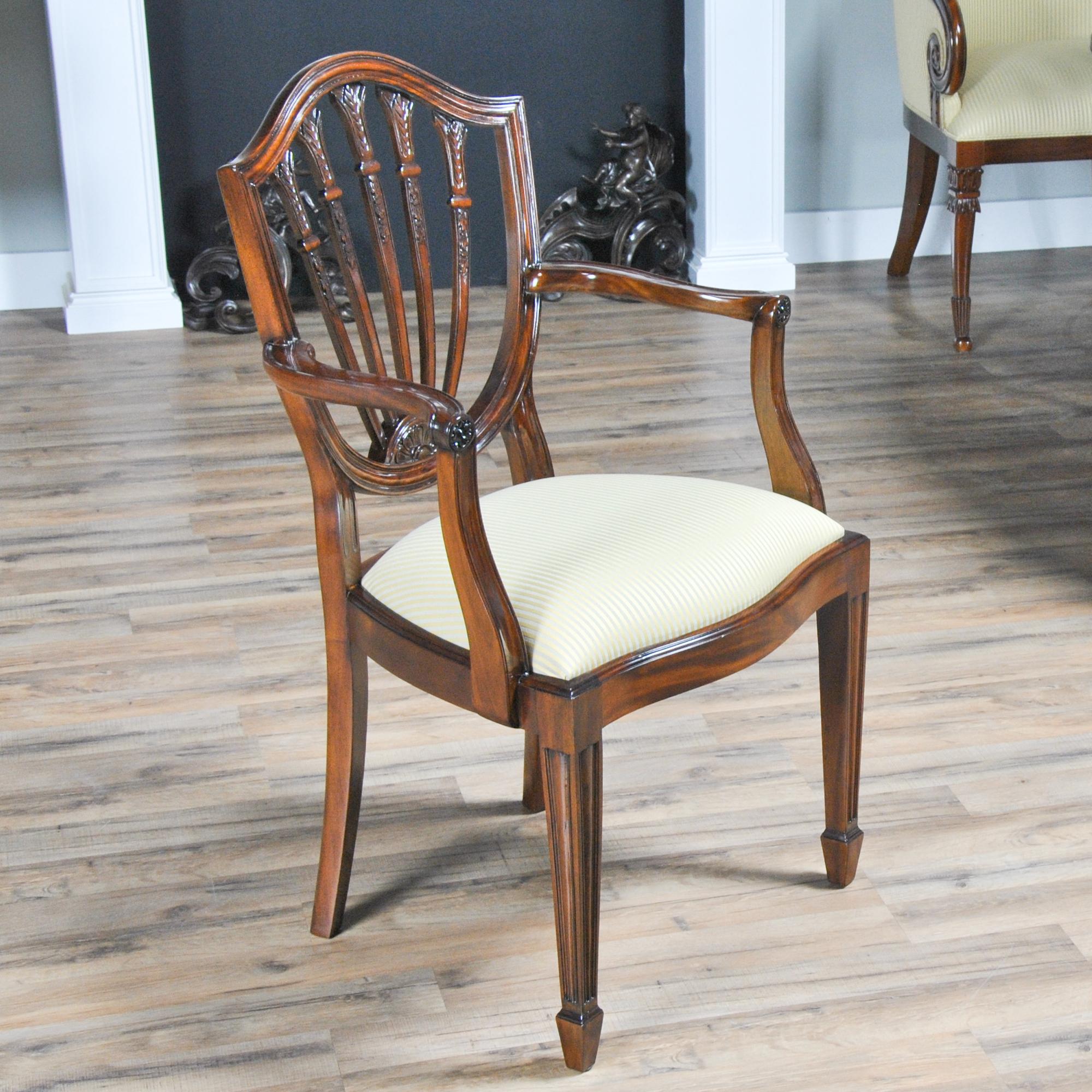 This set of 10 Solid Mahogany, Shield Back Chairs, consist of 2 arm chairs and 8 side chairs. Each chair features a serpentine crest rail which connects to the five section back splat and terminates in a petal carved lunette, all working tougher to