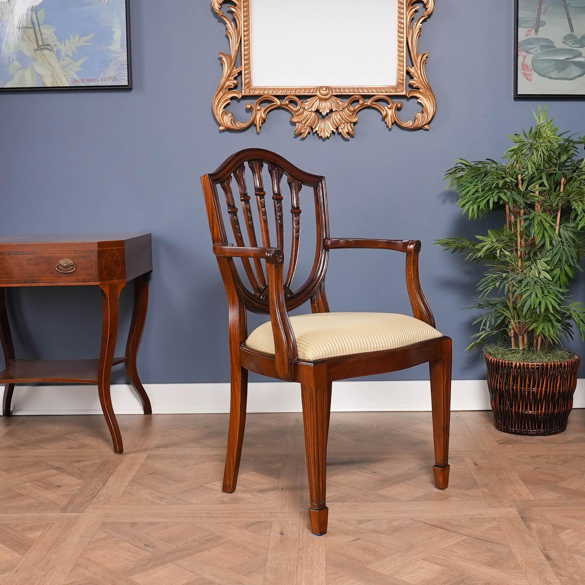 Questo set di 10 sedie con schienale a scudo in mogano massiccio è composto da 2 poltrone e 8 sedie laterali. Ogni sedia è caratterizzata da un binario con cresta a serpentina che si collega allo schienale a cinque sezioni e termina con una lunetta