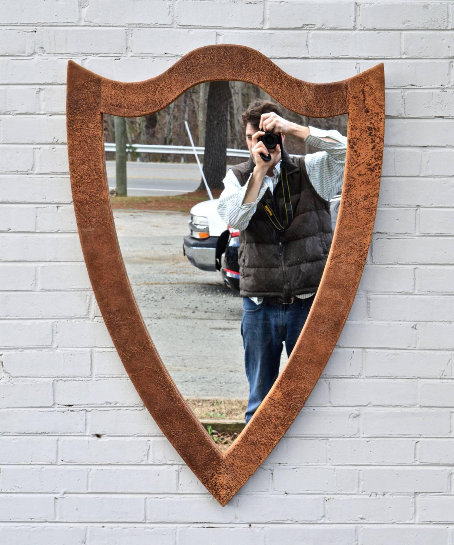 An elegantly rustic shield form mirror of hand wrapped leather. The soft and supple calfskin feels truly luxurious to the touch. This looking glass is equally at home in a rustic chic cabin or above a chest of drawers in an urban loft. Custom sizes